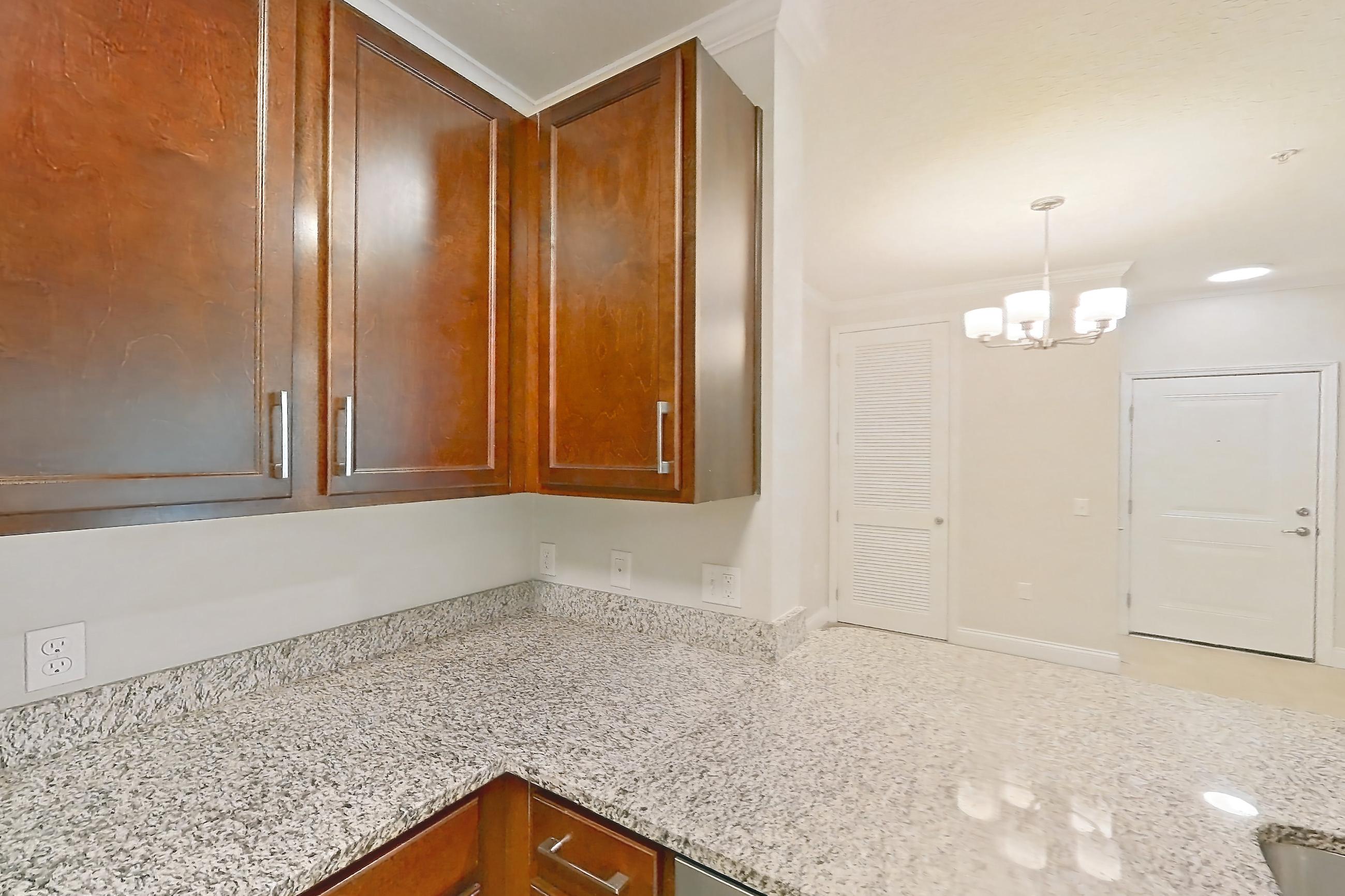 Kitchen with dishwasher, light carpet, light stone countertops, light tile flooring, refrigerator, and stainless steel appliances, Apartment 1524 at Lake Nona Water Mark