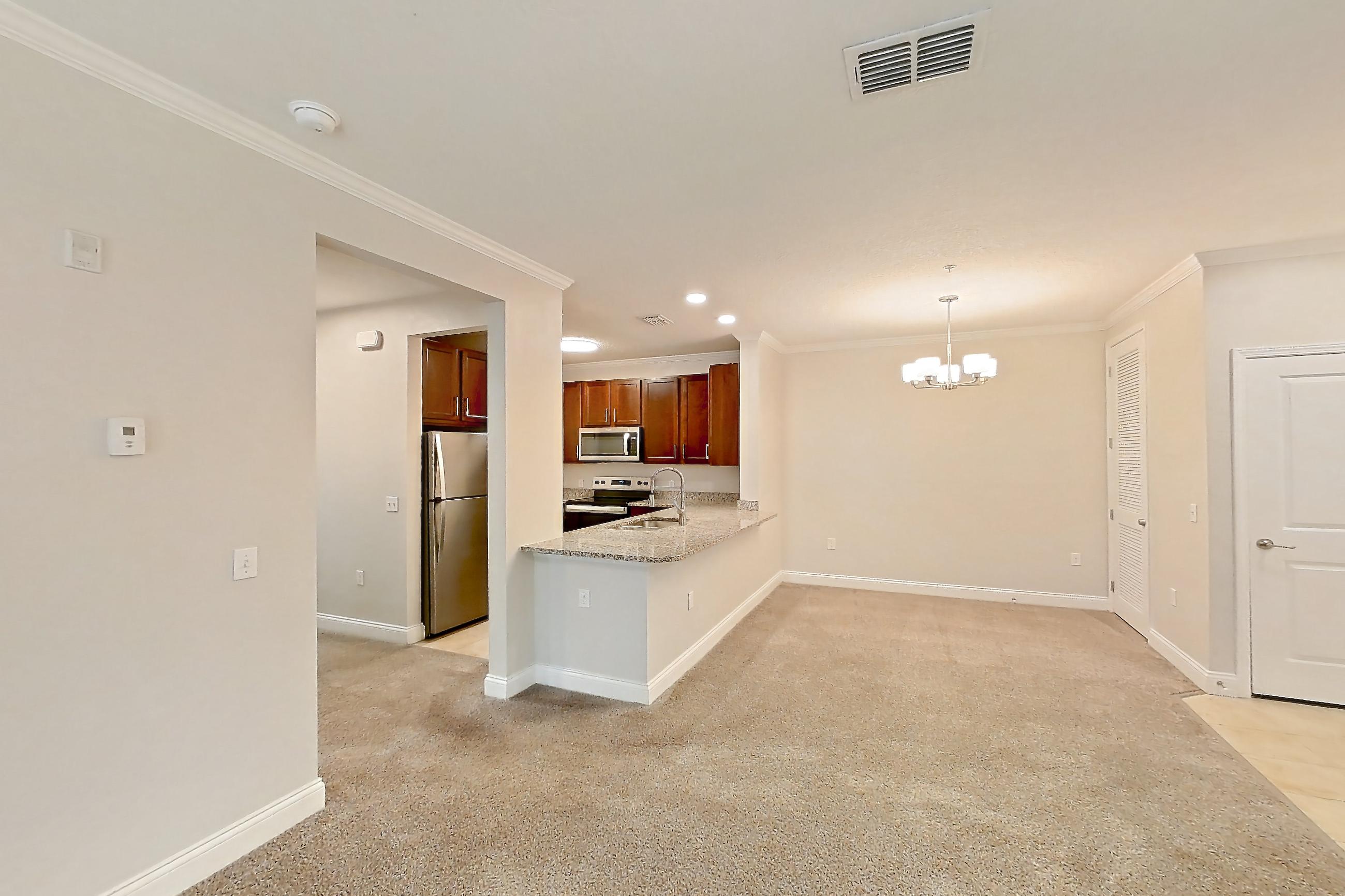 Living room with electric range, light carpet, oven/range, refrigerator, and stainless steel appliances, Apartment 1524 at Lake Nona Water Mark