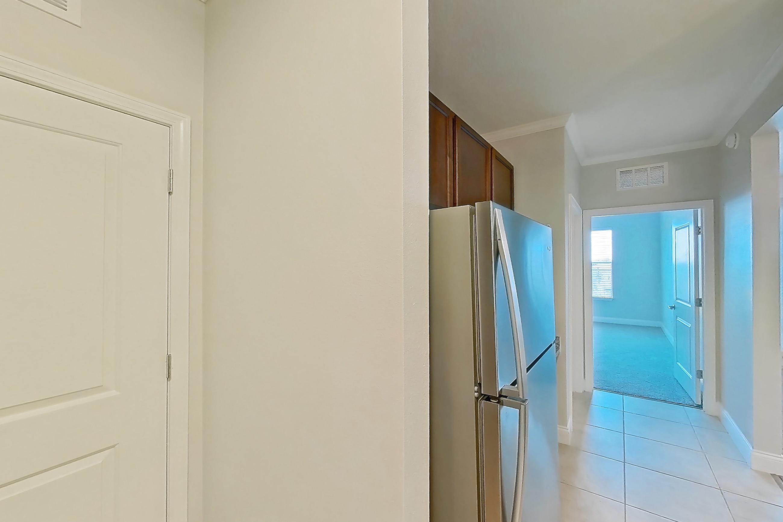 Kitchen with dishwasher, electric range, light countertops, light stone countertops, light tile flooring, microwave, oven/range, refrigerator, and stainless steel appliances, Apartment 1632 at Lake Nona Water Mark