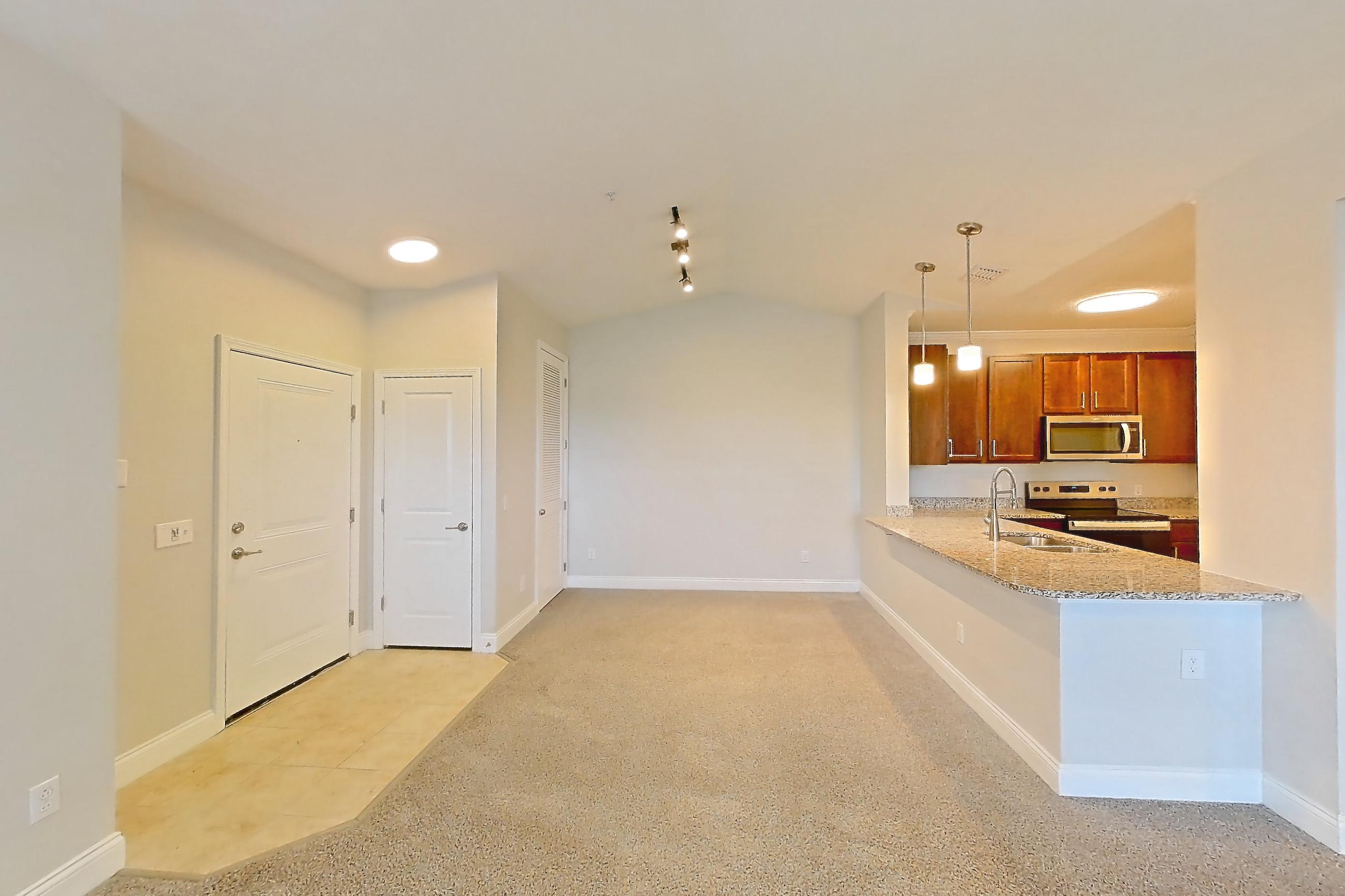Living room with electric range, light carpet, oven/range, refrigerator, and stainless steel appliances, Apartment 1933 at Lake Nona Water Mark