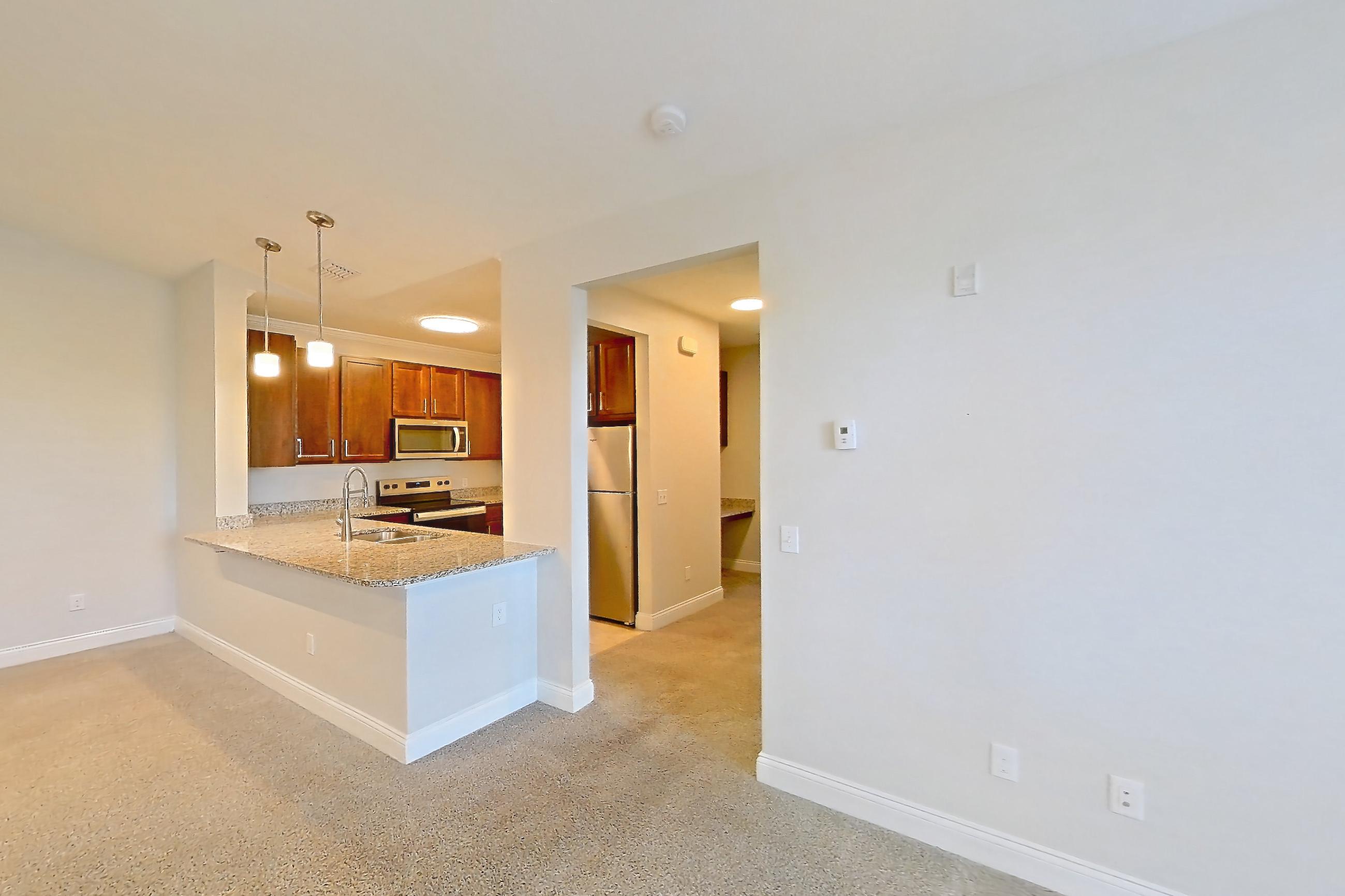 Living room with electric range, light carpet, oven/range, refrigerator, and stainless steel appliances, Apartment 1933 at Lake Nona Water Mark