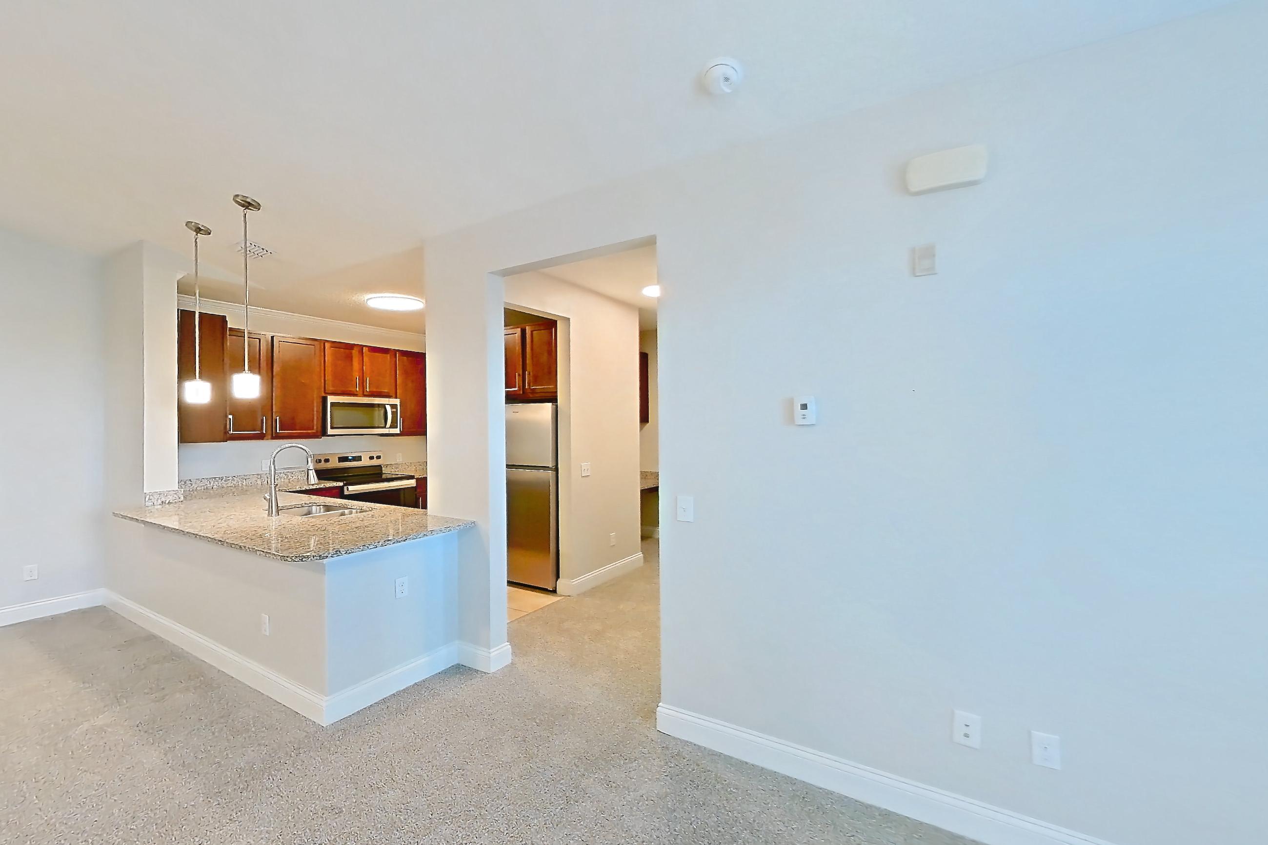 Living room with electric range, light carpet, light tile flooring, oven/range, refrigerator, and stainless steel appliances, Apartment 2233 at Lake Nona Water Mark