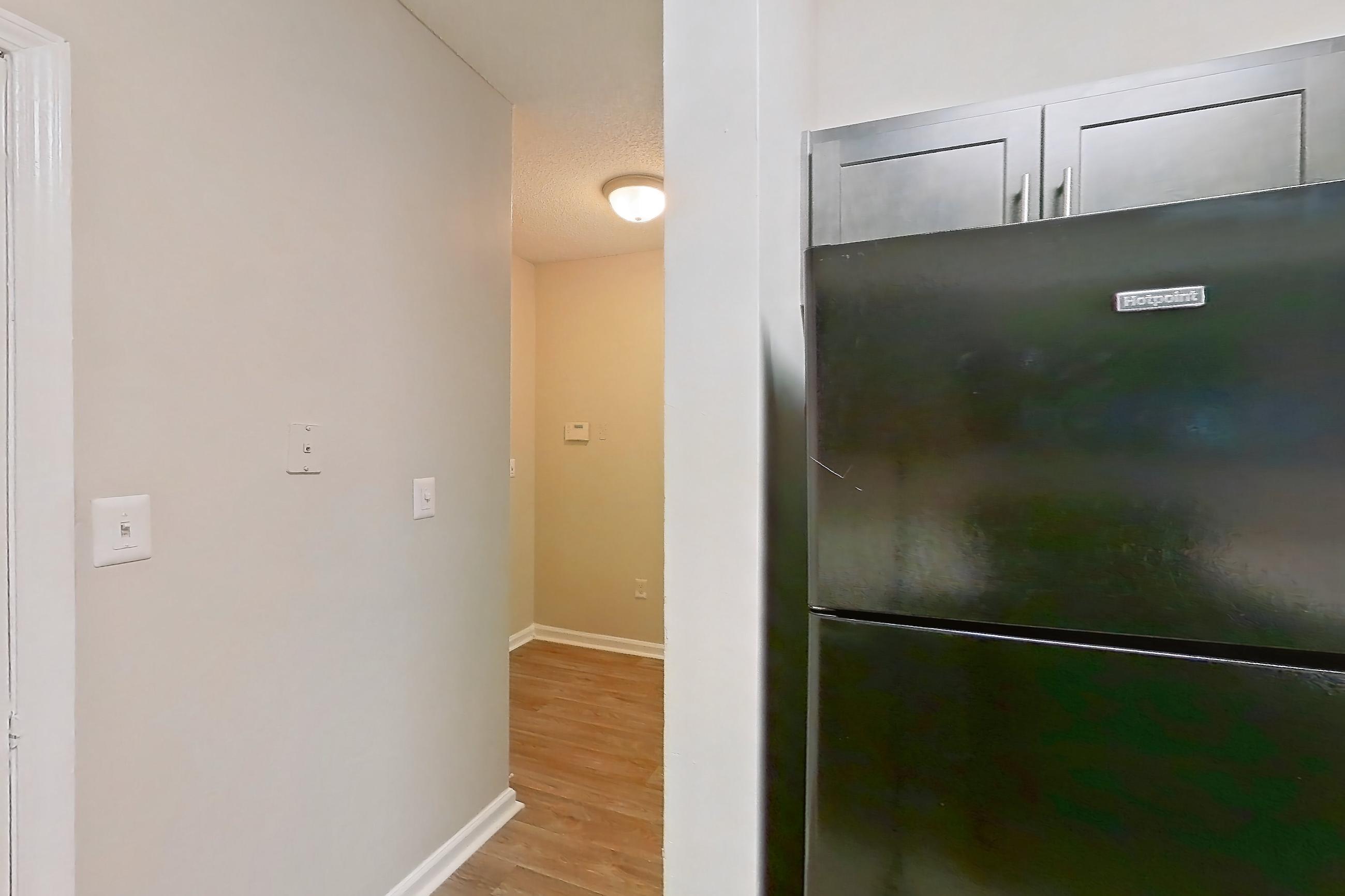 Kitchen with black appliances, electric range, light countertops, light wood-finish flooring, oven/range, and refrigerator, Apartment 211 at Walden Landing