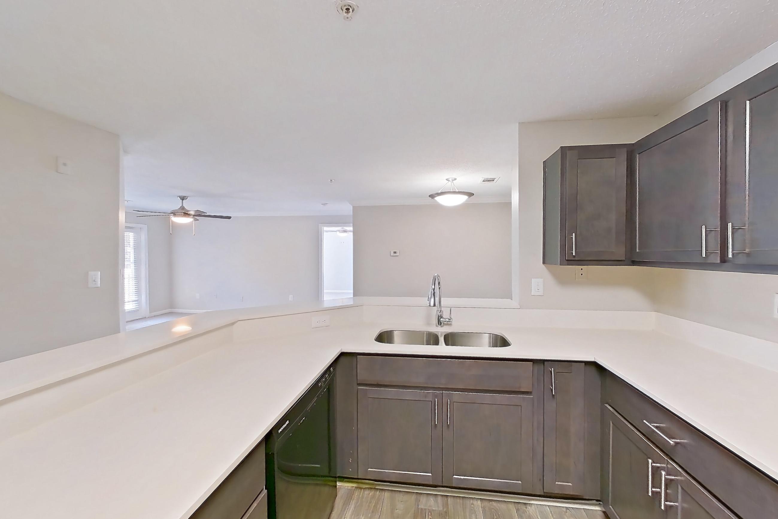 Kitchen with black appliances, dishwasher, electric range, light countertops, light wood-finish flooring, microwave, and oven/range, Apartment 527 at Walden Landing