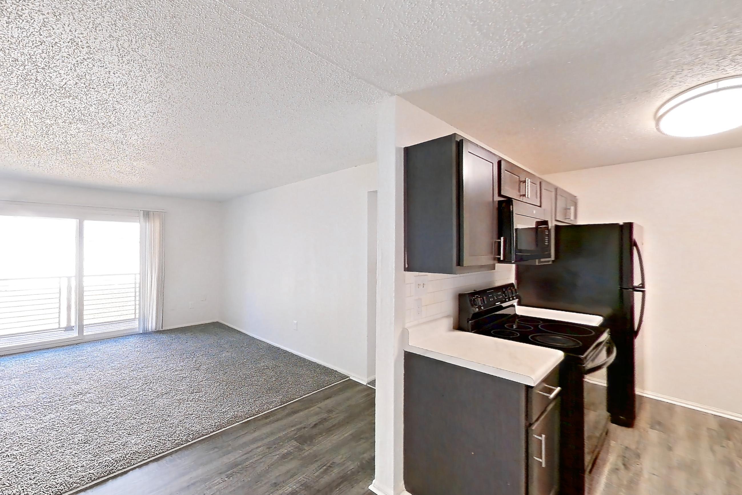 Dining room with black appliances, dark wood-finish flooring, electric range, light countertops, oven/range, and refrigerator, Apartment 48 at Woodwinds