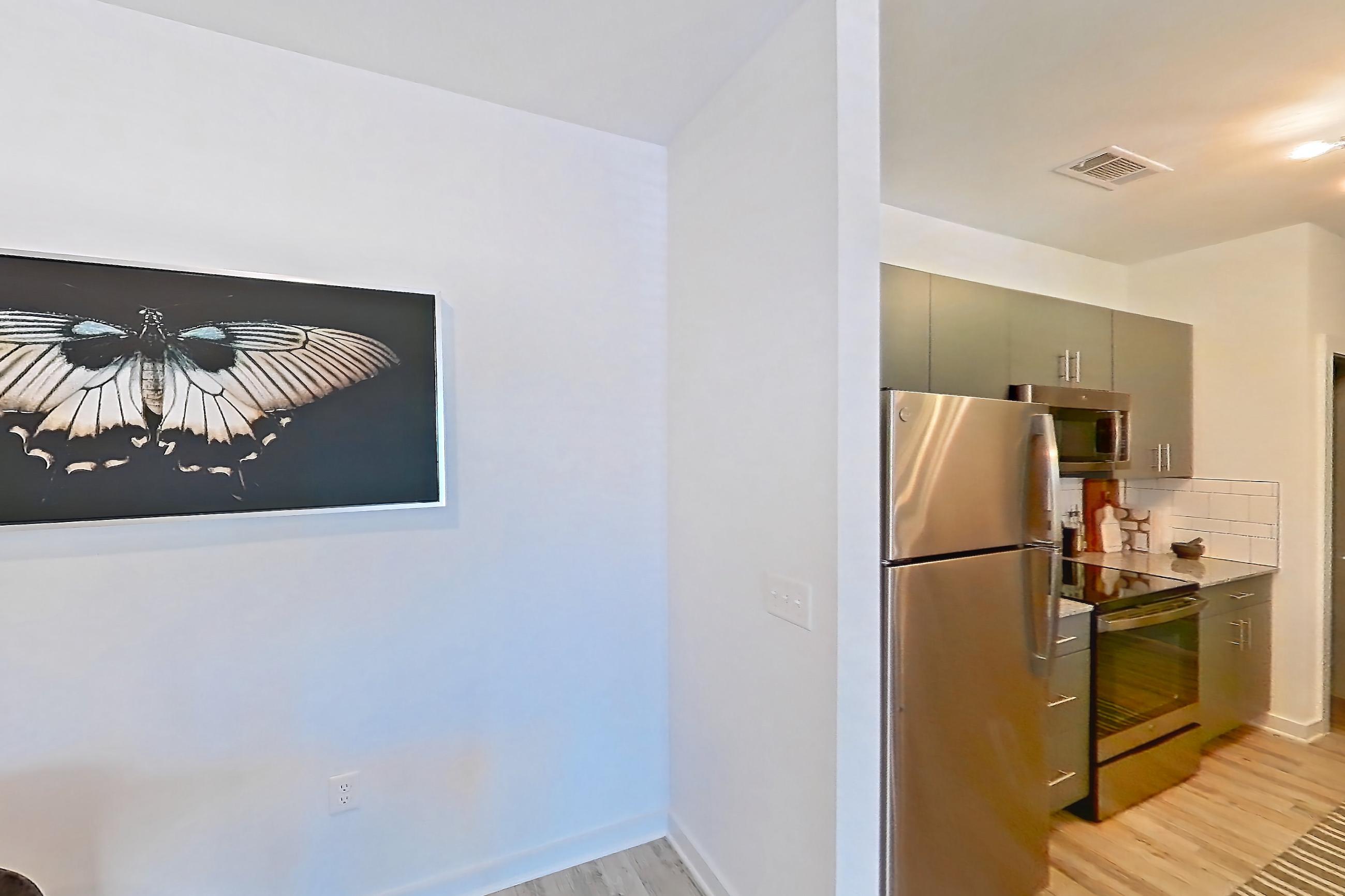Dining room with electric range, light stone countertops, light wood-finish flooring, oven/range, refrigerator, and stainless steel appliances, Apartment 1211-102 at Avril Cambridge Village