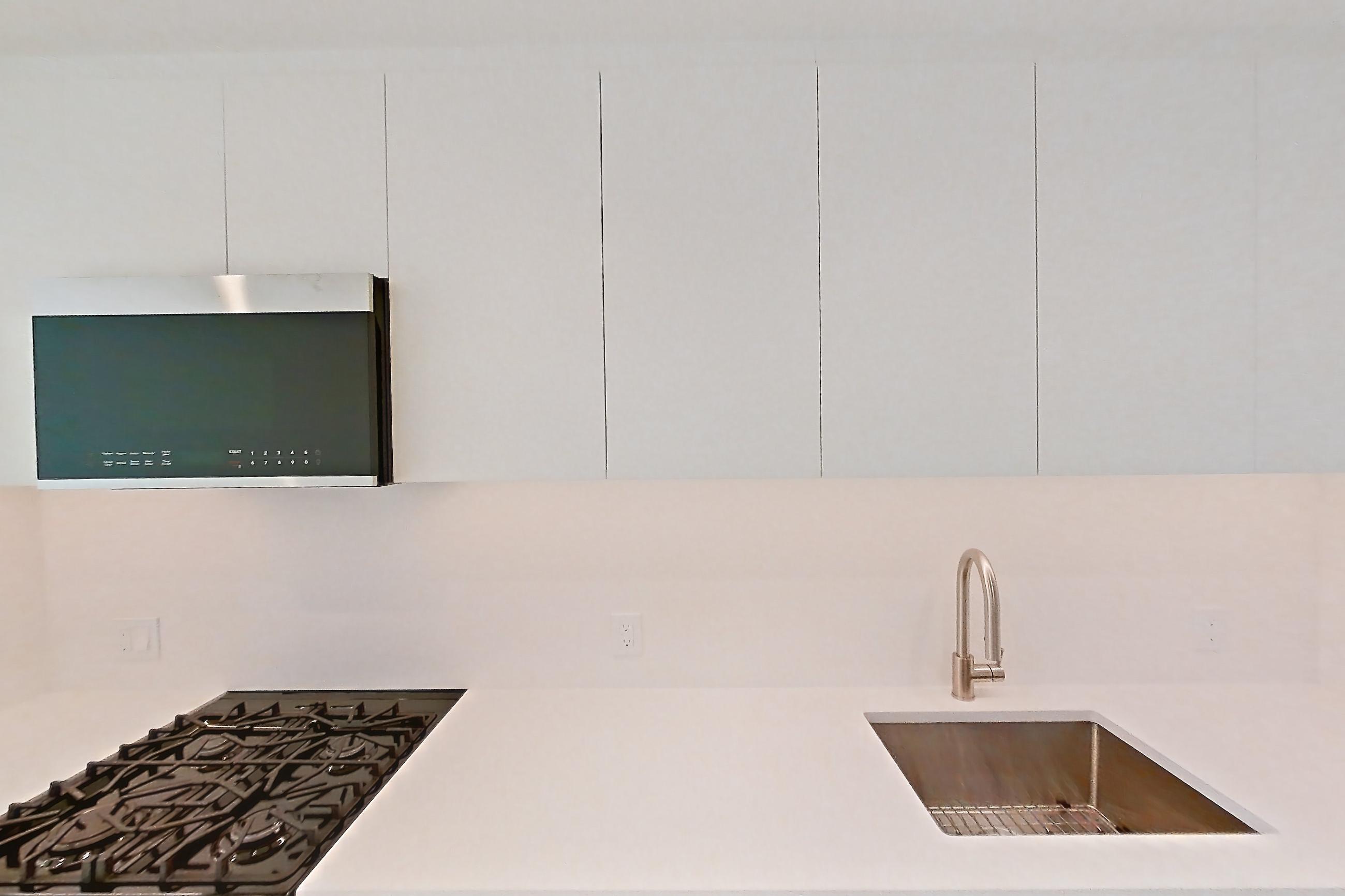 Kitchen with dishwasher, gas range, light countertops, light wood-finish flooring, oven/range, refrigerator, and stainless steel appliances, Apartment 56G at Lumen
