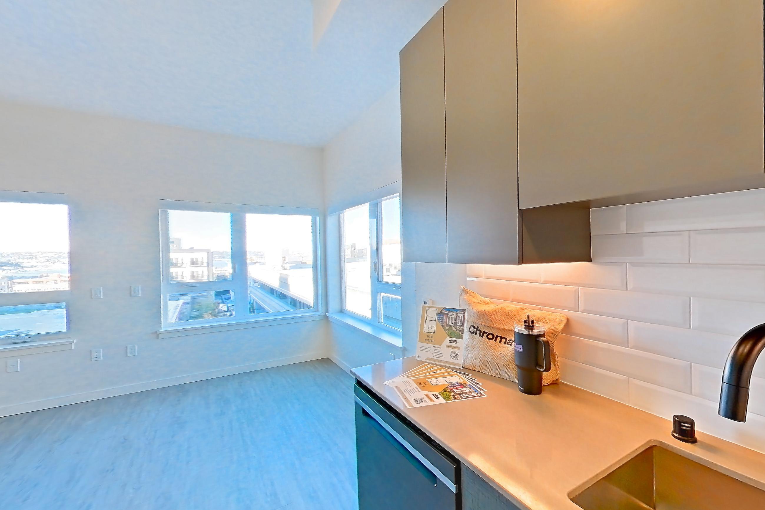 Kitchen with dishwasher, electric range, light stone countertops, light wood-finish flooring, microwave, oven/range, and stainless steel appliances, Apartment 711W at Chroma
