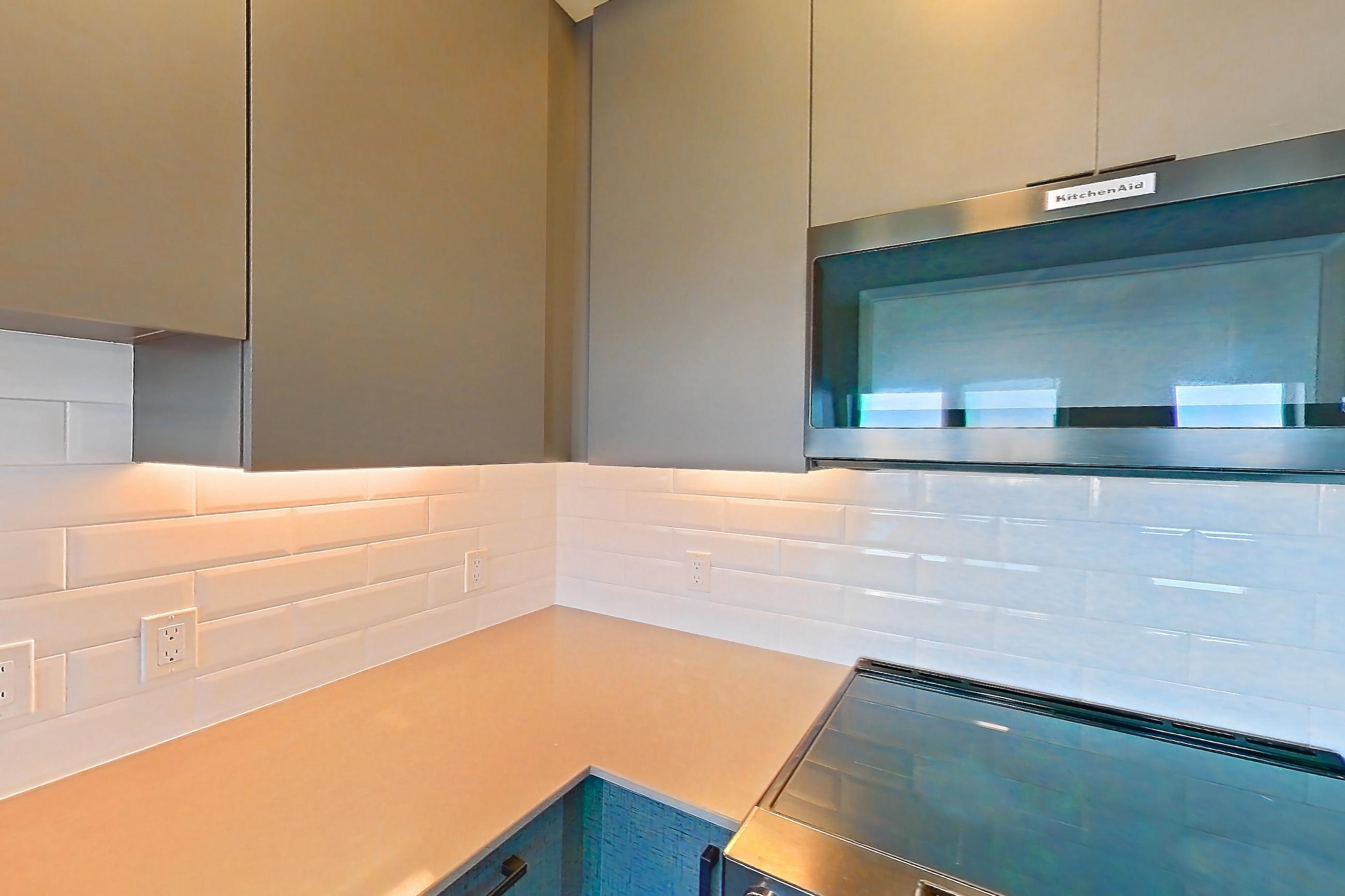 Kitchen with dishwasher, electric range, light stone countertops, light wood-finish flooring, microwave, oven/range, and stainless steel appliances, Apartment 711W at Chroma