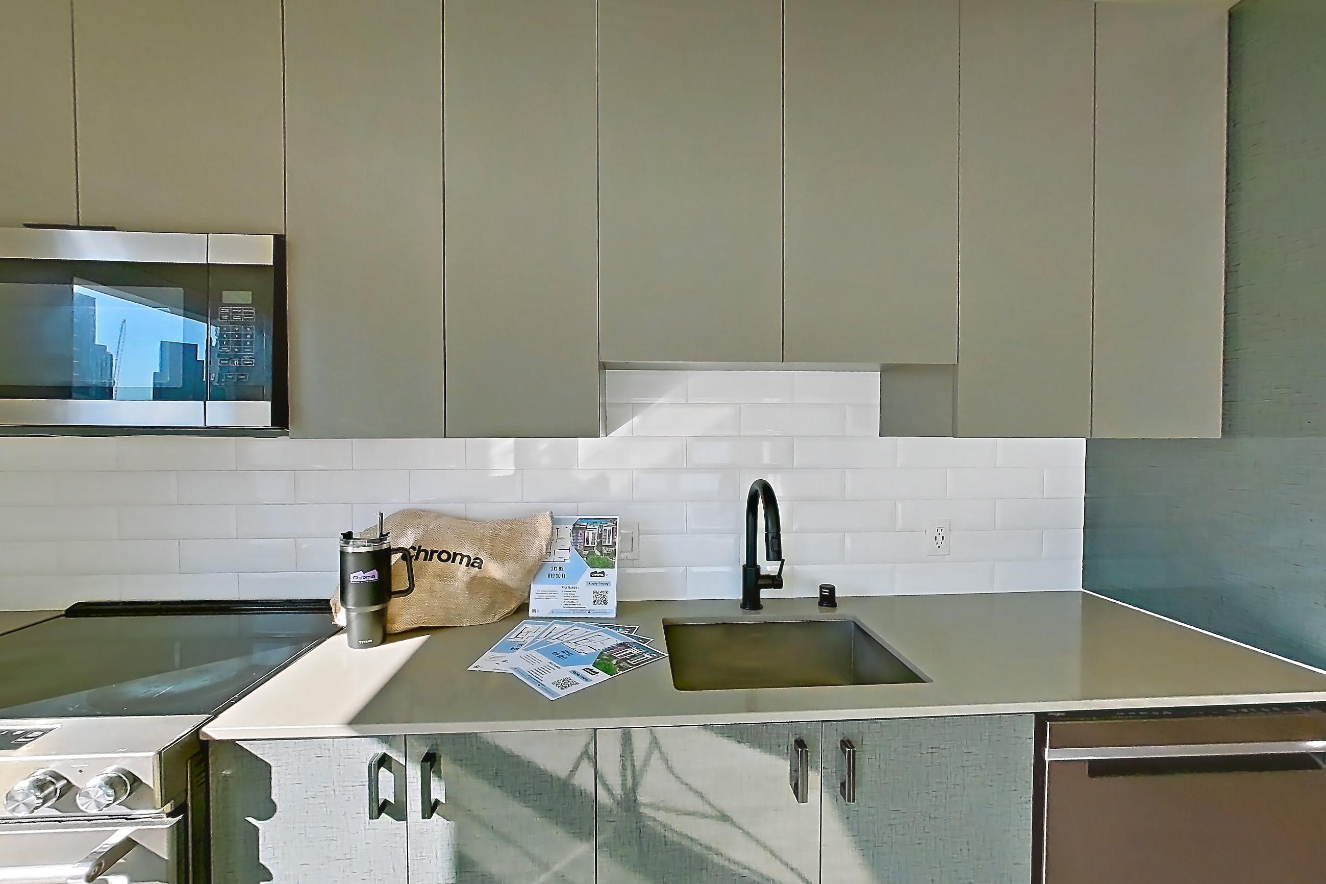 Kitchen with light countertops, light wood-finish flooring, oven/range, refrigerator, and stainless steel appliances, Unit 725W at Chroma
