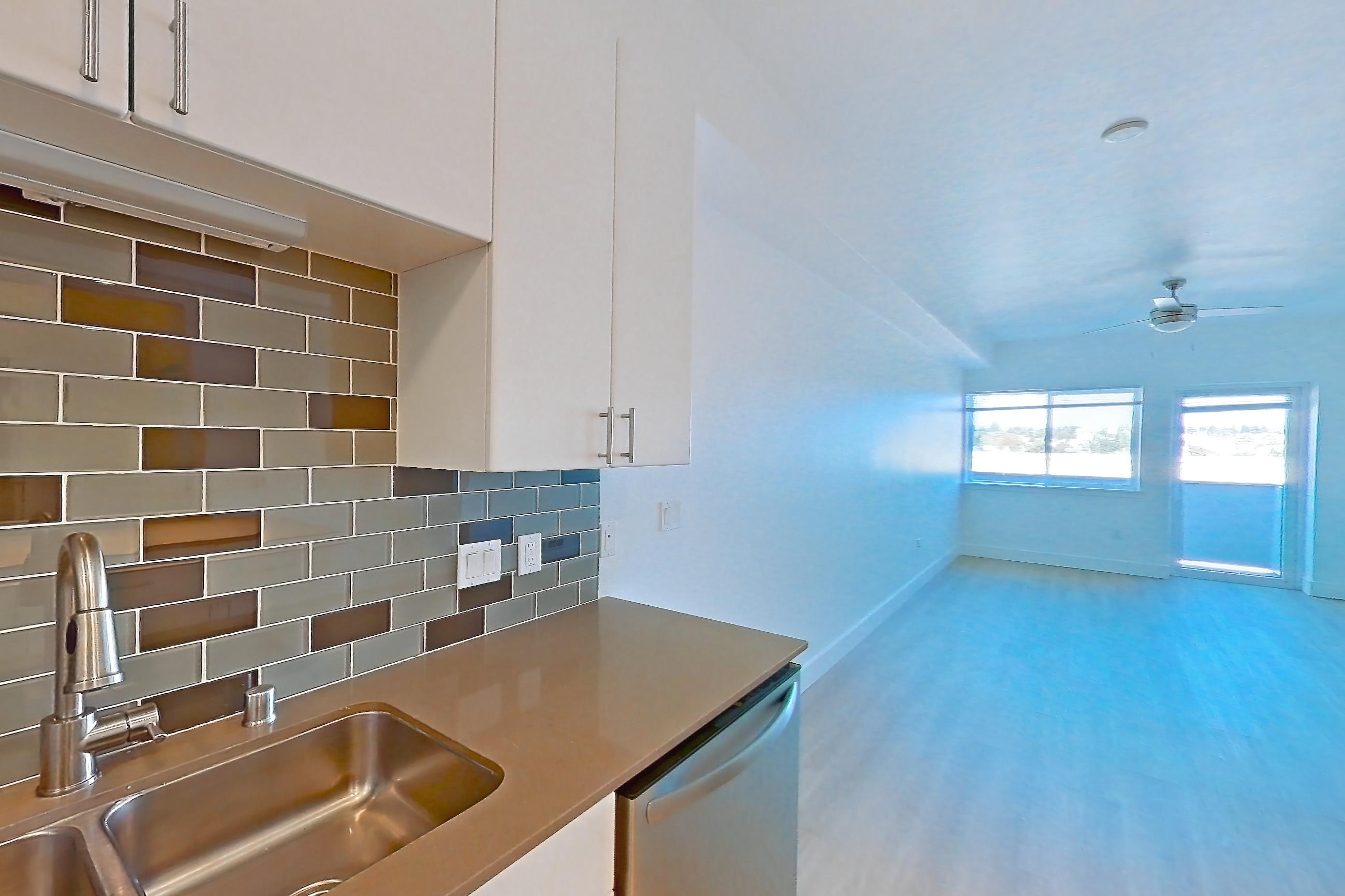 Kitchen with dishwasher, electric range, light countertops, light wood-finish flooring, oven/range, refrigerator, and stainless steel appliances, Unit 826 at The Waymark