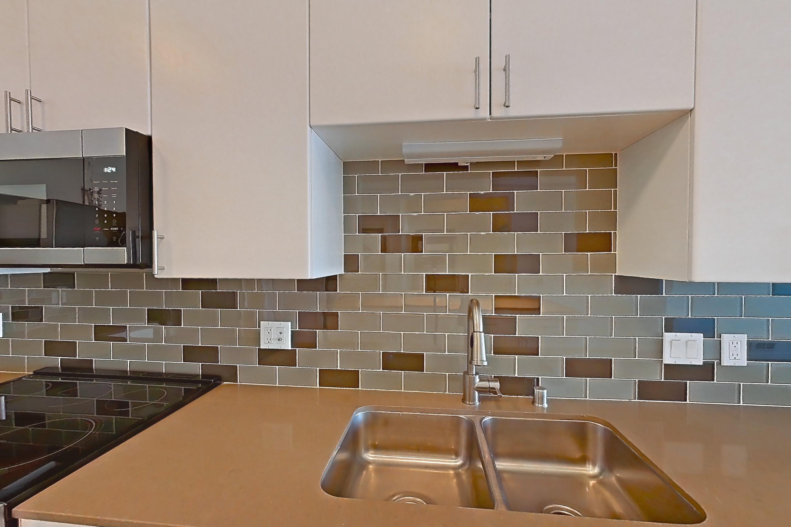 Kitchen with dishwasher, electric range, light countertops, light wood-finish flooring, oven/range, refrigerator, and stainless steel appliances, Unit 826 at The Waymark