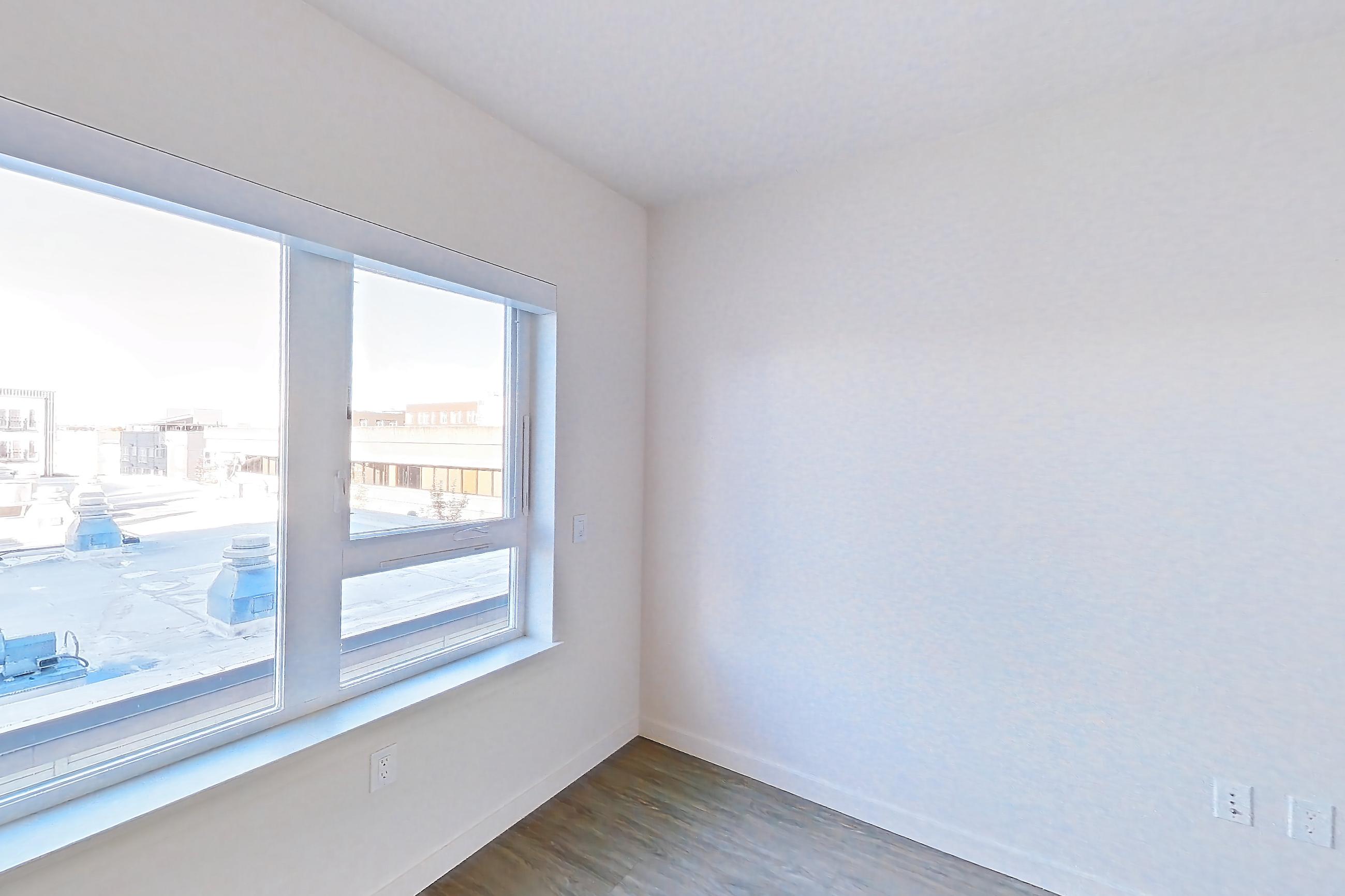Living space with dark wood-finish flooring, dishwasher, gas range, light wood-finish flooring, and stainless steel appliances, Apartment 609W at Chroma