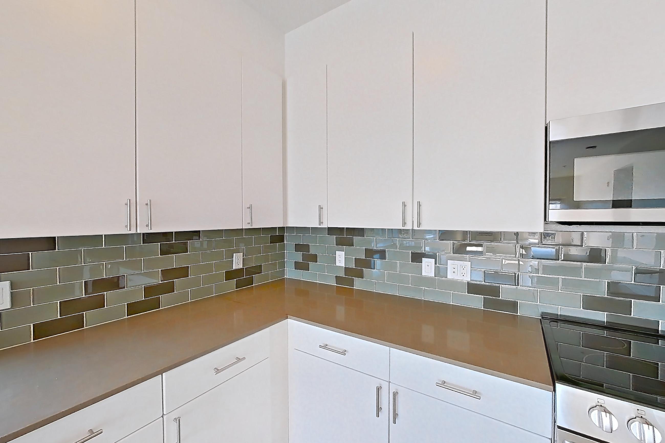 Kitchen with dishwasher, electric range, light countertops, light wood-finish flooring, microwave, oven/range, refrigerator, and stainless steel appliances, Unit 811 at The Waymark