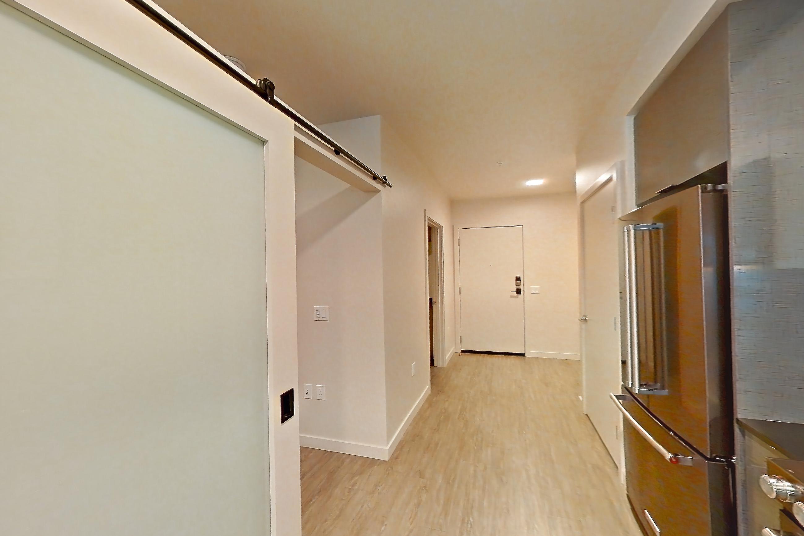 Kitchen with dark countertops, light countertops, light wood-finish flooring, microwave, oven/range, refrigerator, and stainless steel appliances, Unit 409W at Chroma
