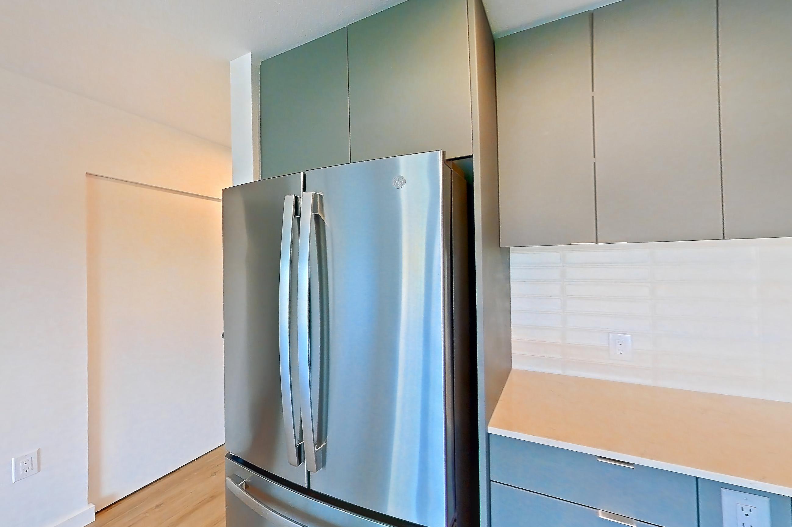Kitchen with electric range, light countertops, light stone countertops, light wood-finish flooring, microwave, oven/range, refrigerator, and stainless steel appliances, Unit 180 at Arlo