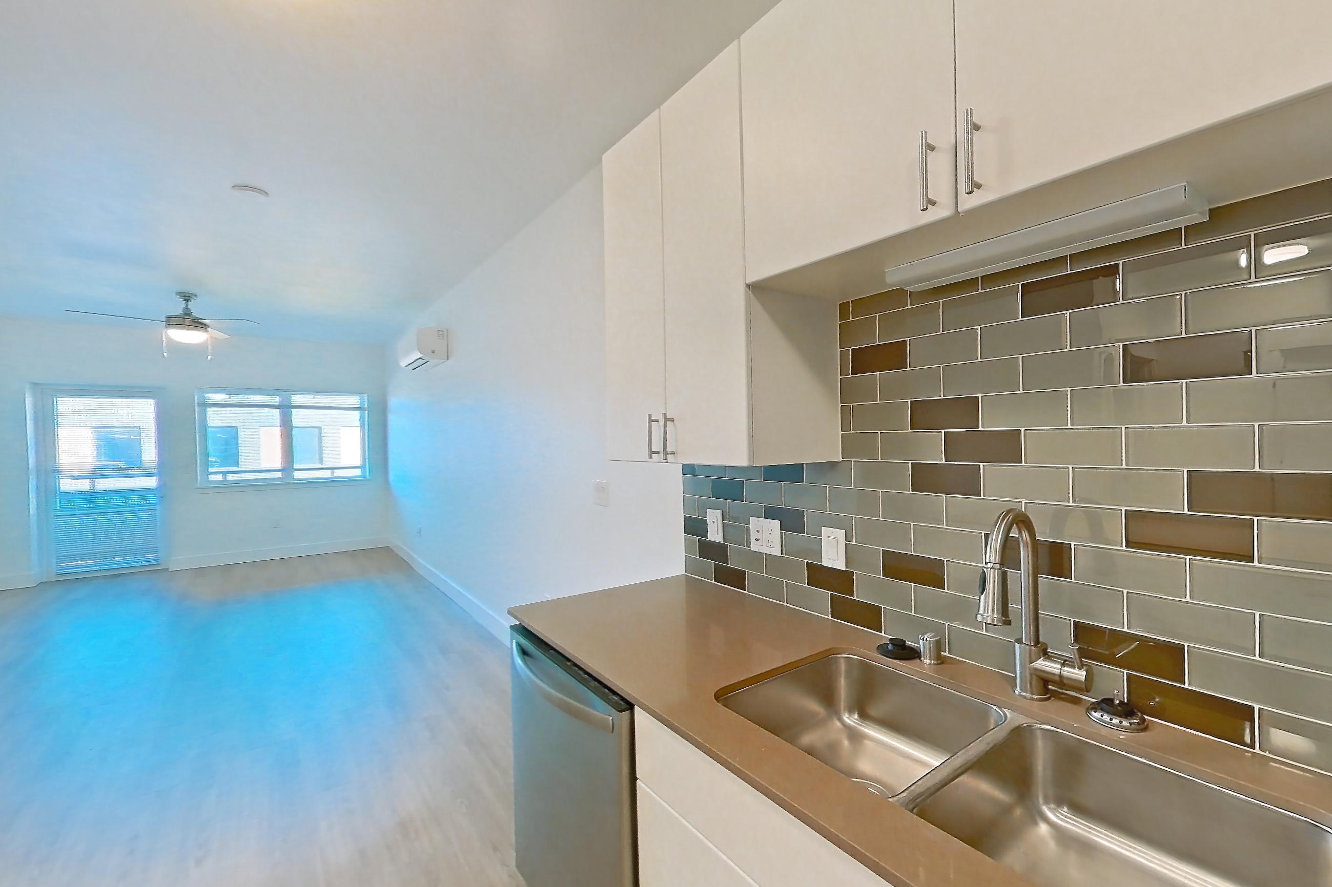 Kitchen with dishwasher, electric range, light countertops, light wood-finish flooring, oven/range, refrigerator, and stainless steel appliances, Apartment 534 at The Waymark