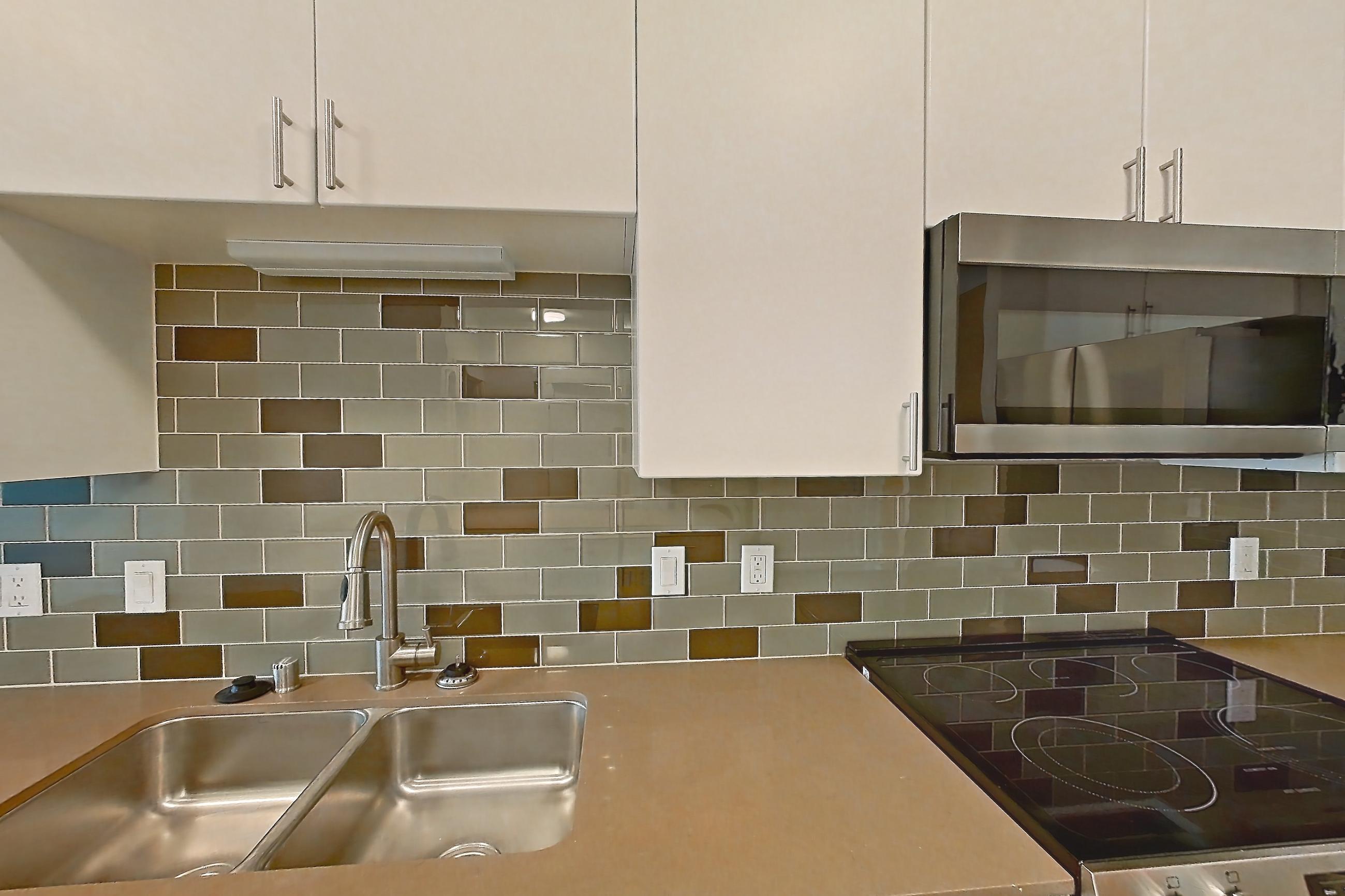 Kitchen with dishwasher, electric range, light countertops, light wood-finish flooring, oven/range, refrigerator, and stainless steel appliances, Apartment 534 at The Waymark