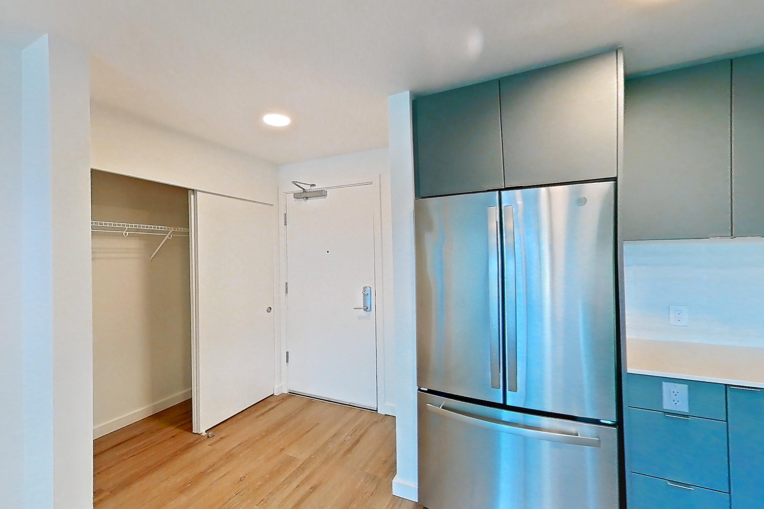Kitchen with dishwasher, electric range, light countertops, light stone countertops, light wood-finish flooring, microwave, oven/range, refrigerator, and stainless steel appliances, Unit 174 at Arlo