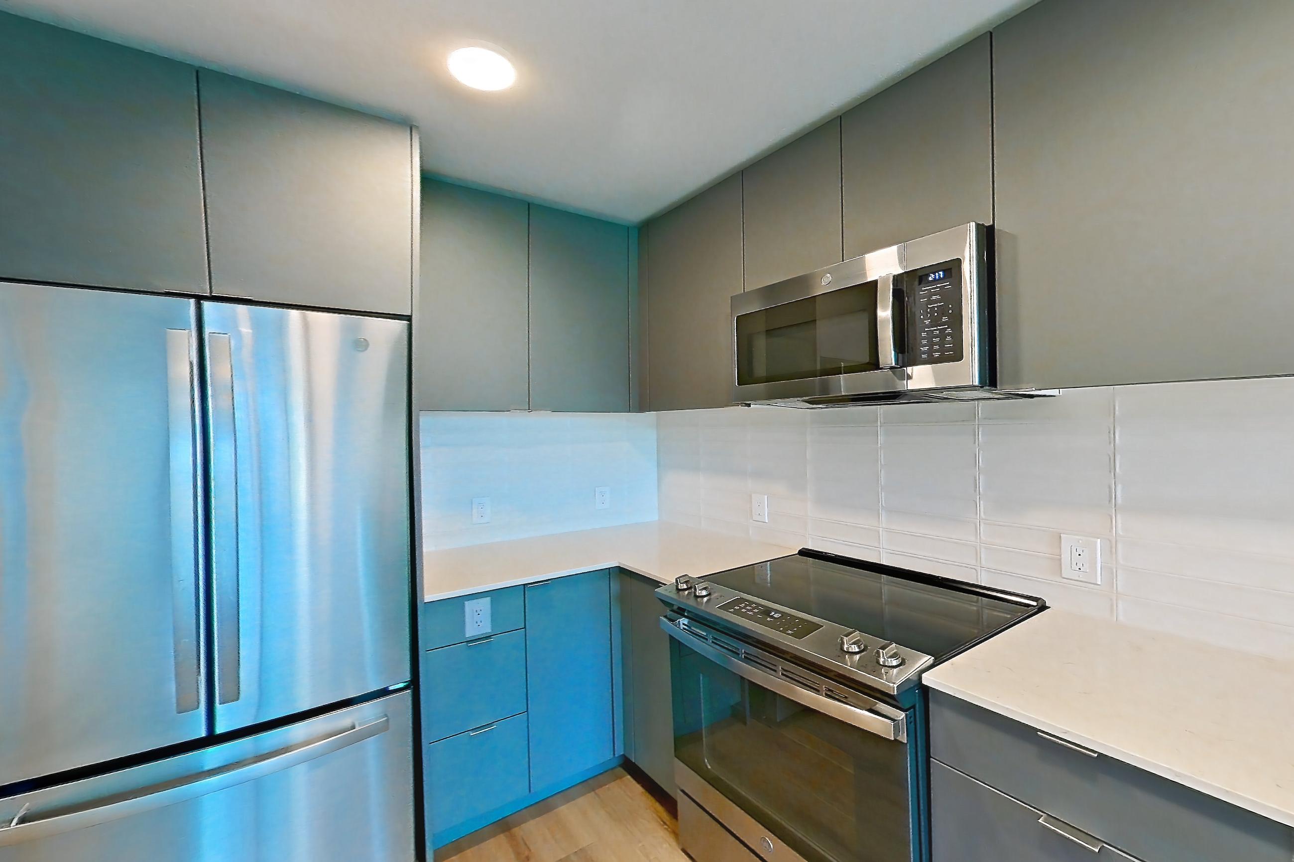 Kitchen with dishwasher, electric range, light countertops, light stone countertops, light wood-finish flooring, microwave, oven/range, refrigerator, and stainless steel appliances, Unit 174 at Arlo