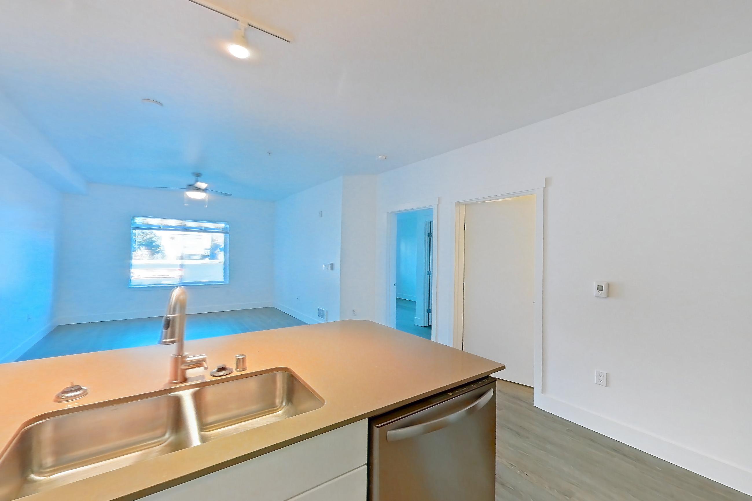 Kitchen with dishwasher, electric range, light countertops, light wood-finish flooring, microwave, oven/range, refrigerator, and stainless steel appliances, Apartment 329 at The Waymark