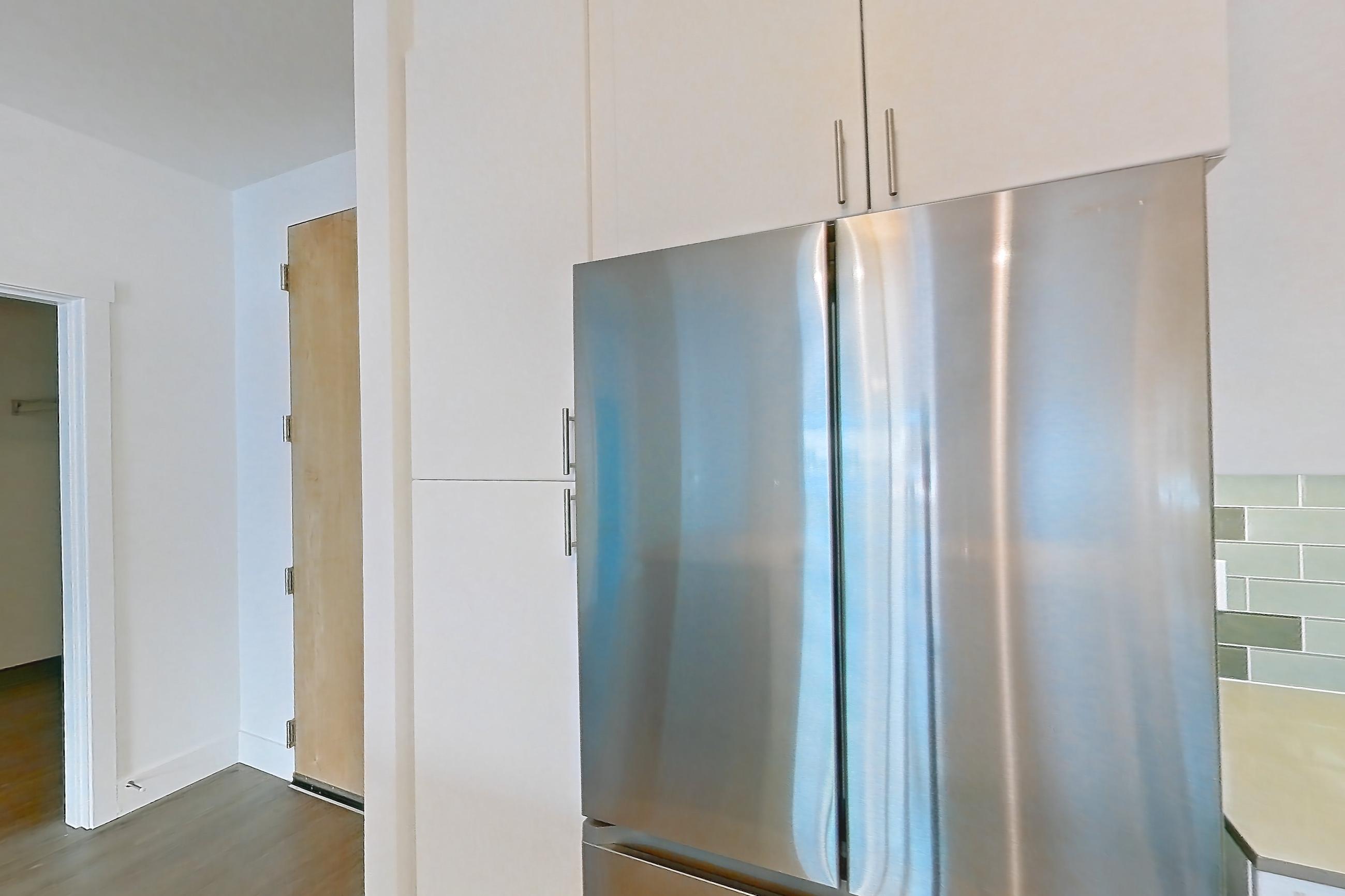 Kitchen with dishwasher, electric range, light countertops, light wood-finish flooring, microwave, oven/range, refrigerator, and stainless steel appliances, Apartment 329 at The Waymark