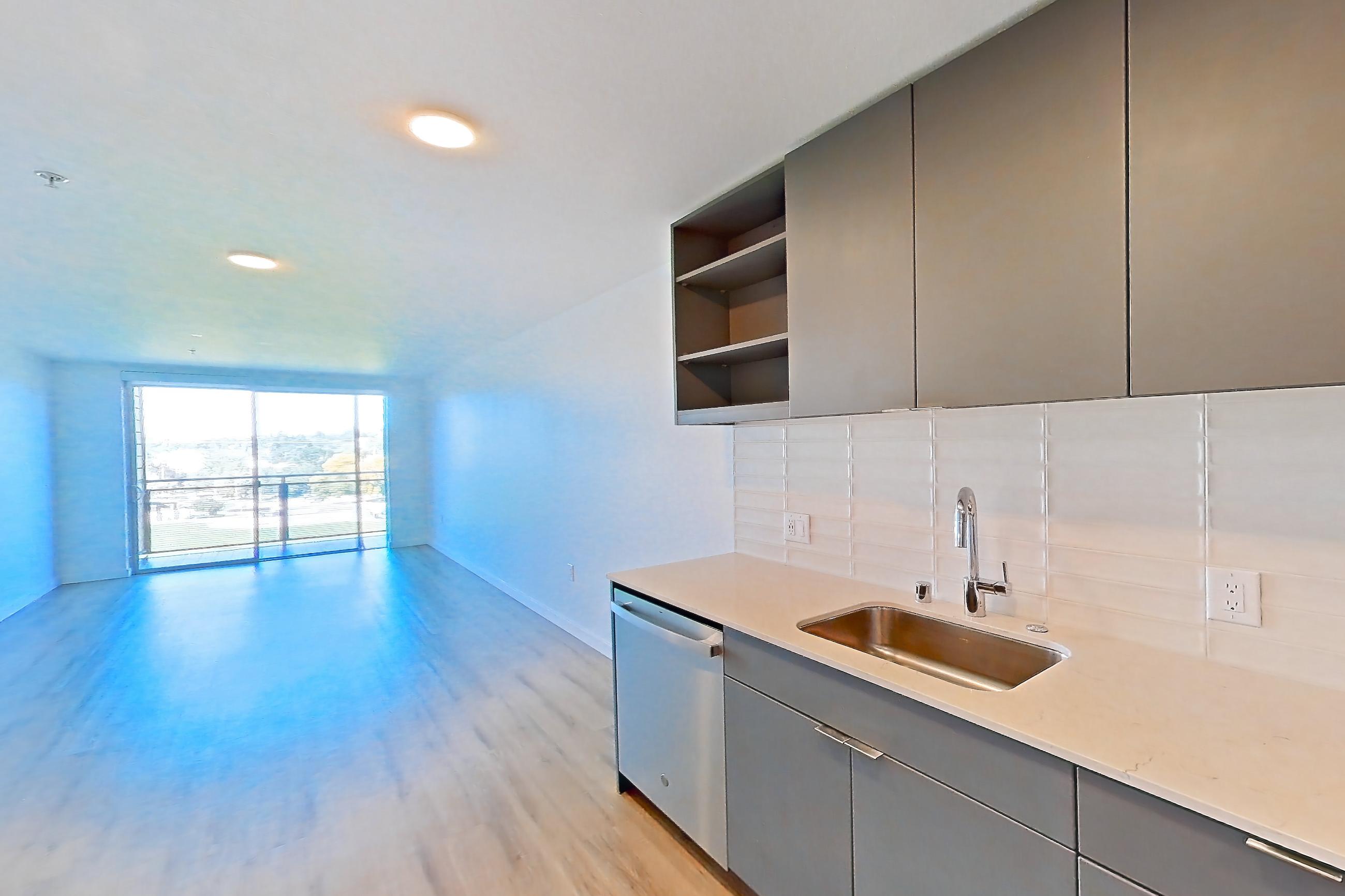 Kitchen with dishwasher, electric range, light countertops, light stone countertops, light wood-finish flooring, microwave, oven/range, refrigerator, and stainless steel appliances, Unit 376 at Arlo