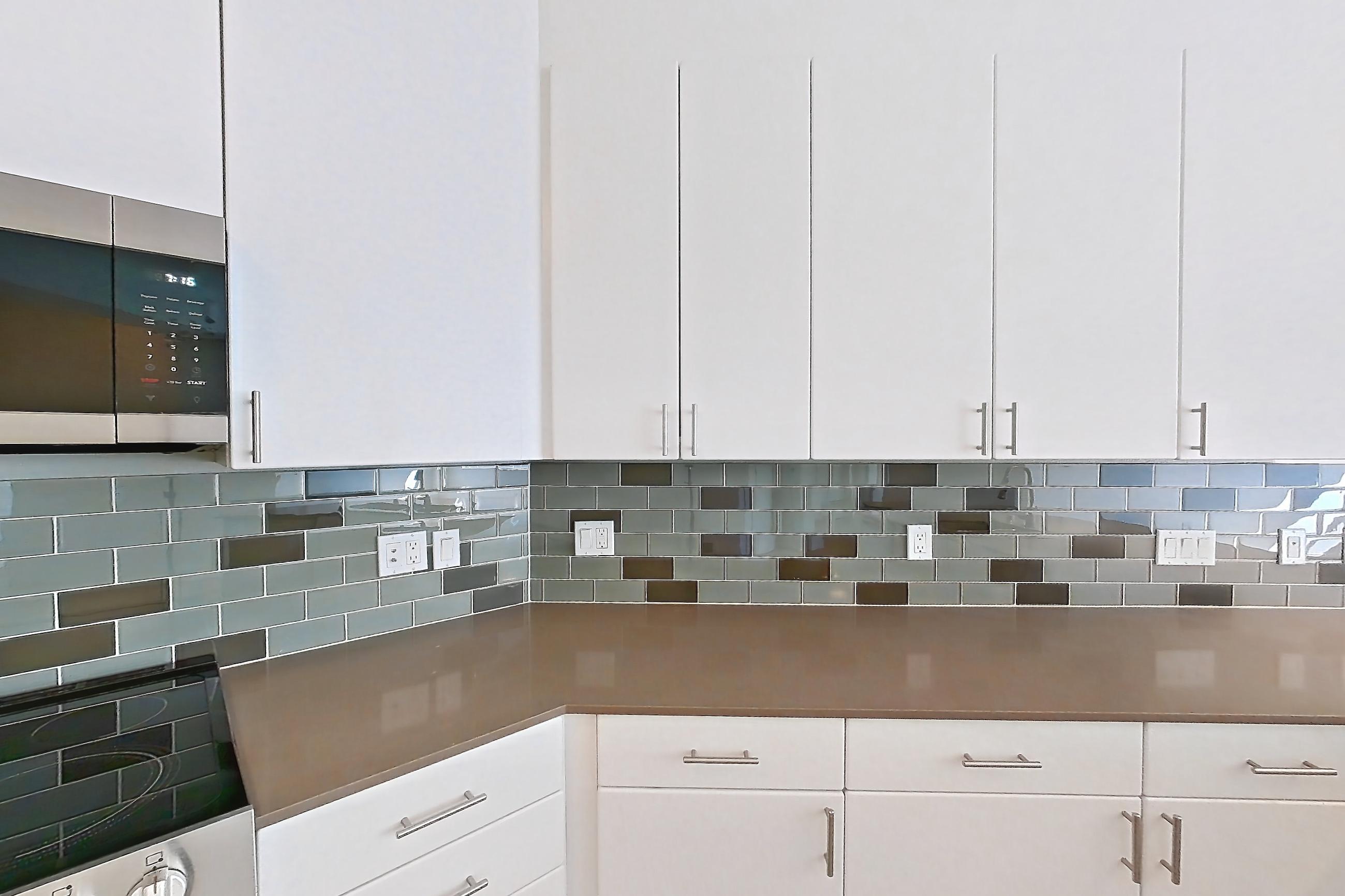Kitchen with dishwasher, electric range, light countertops, light wood-finish flooring, oven/range, refrigerator, and stainless steel appliances, Unit 801 at The Waymark