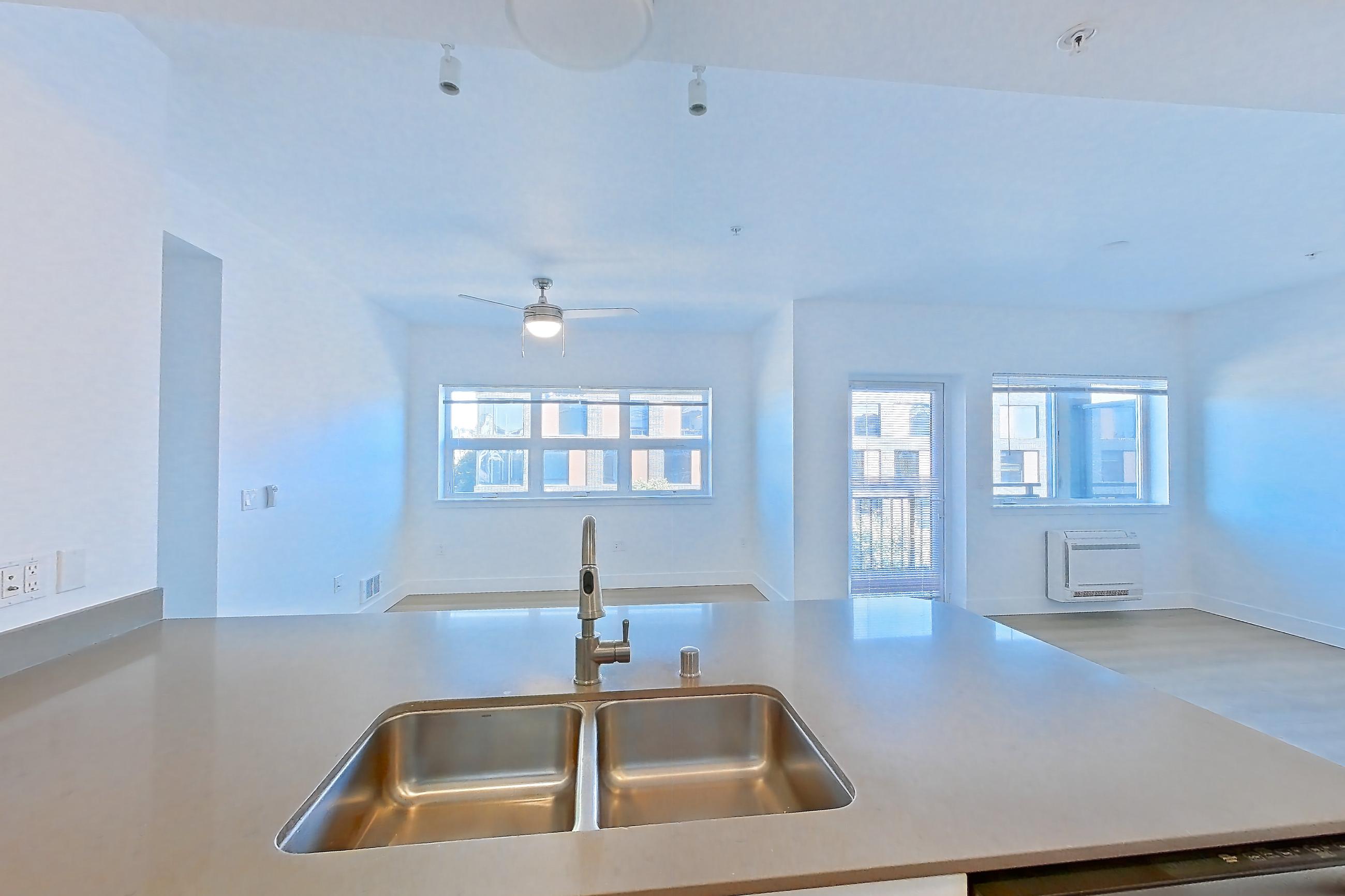 Kitchen with dishwasher, electric range, light countertops, light wood-finish flooring, microwave, oven/range, refrigerator, and stainless steel appliances, Unit 432 at The Waymark
