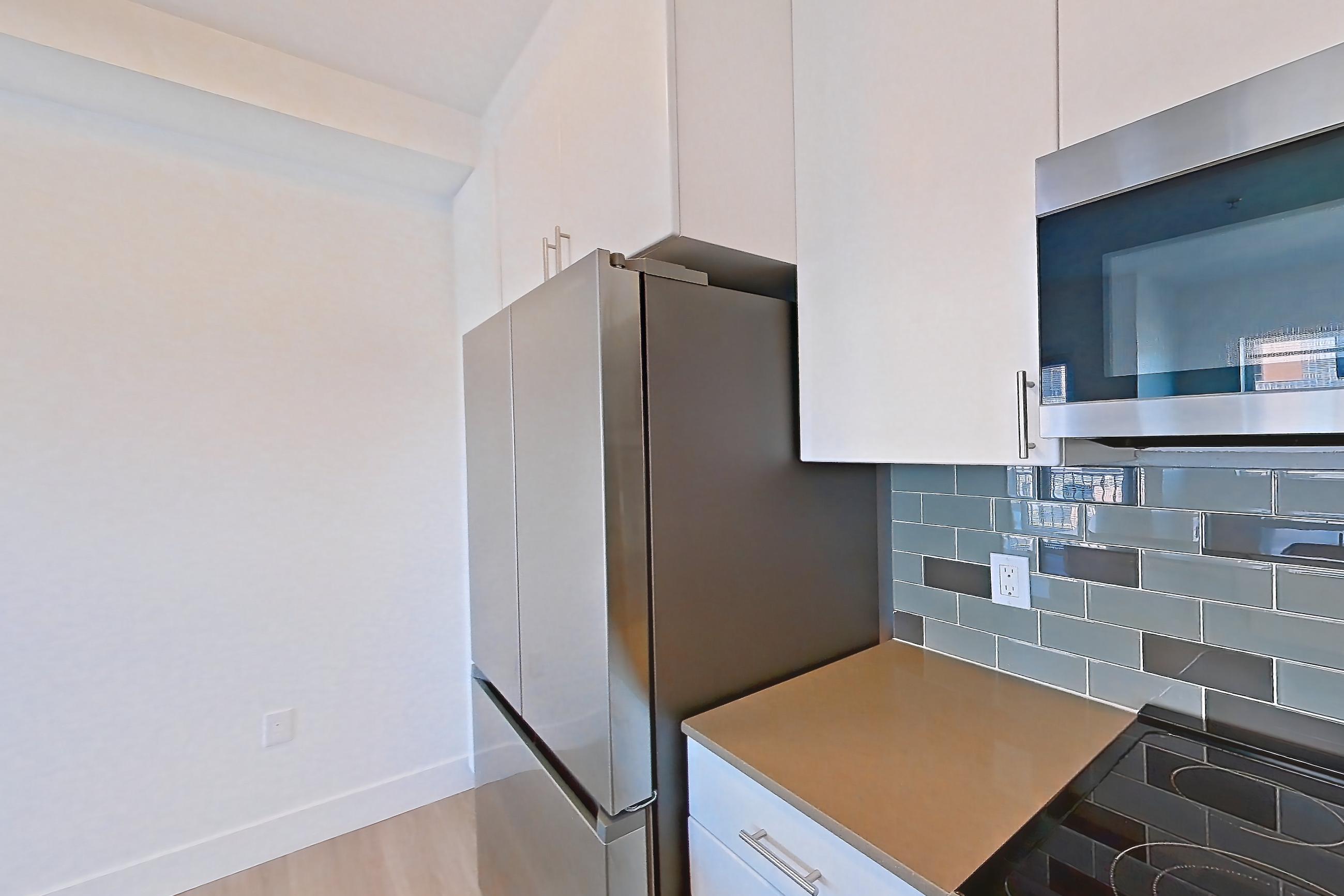 Kitchen with dishwasher, electric range, light countertops, light wood-finish flooring, microwave, oven/range, refrigerator, and stainless steel appliances, Unit 432 at The Waymark