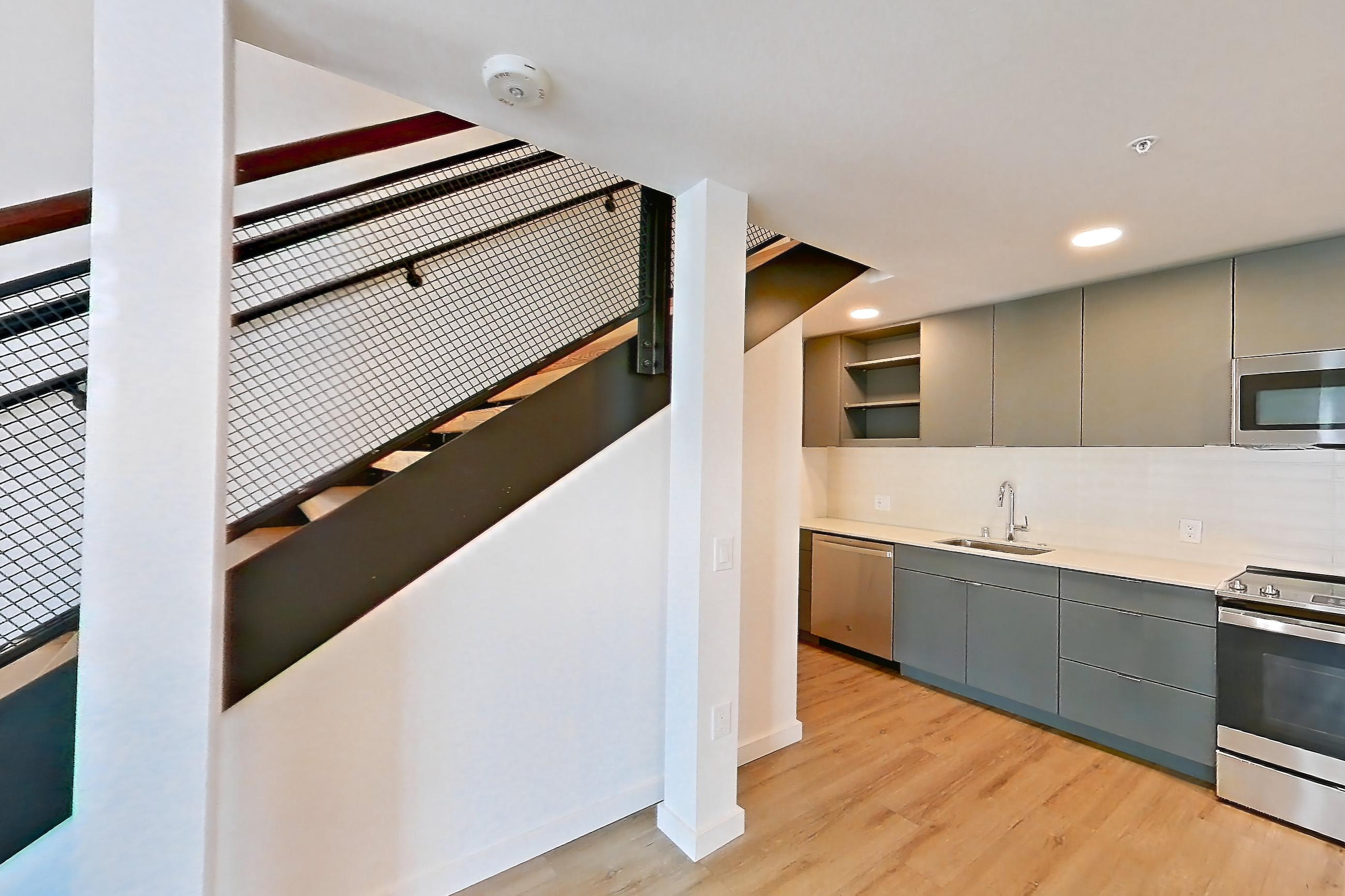 Living space with dishwasher, light wood-finish flooring, and stainless steel appliances, Unit 130 at Arlo