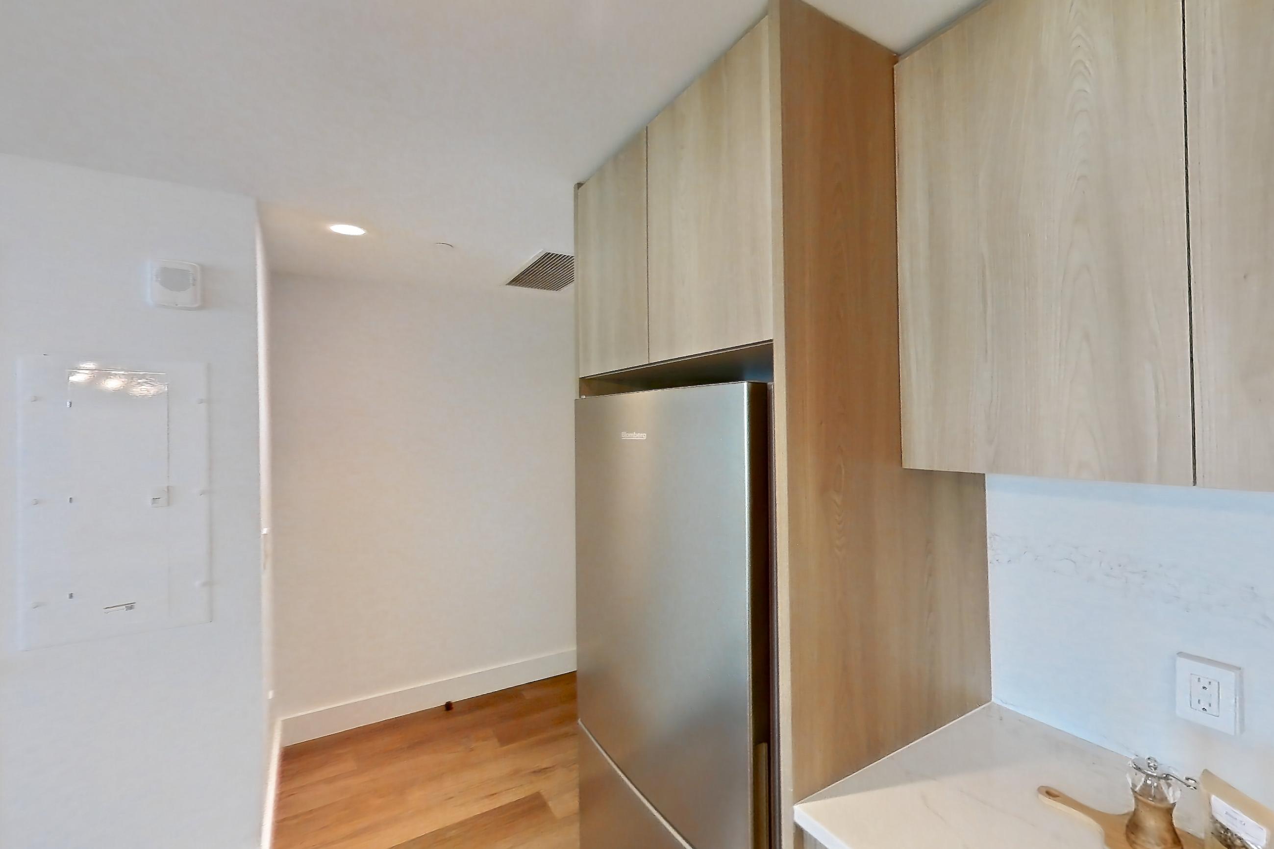 Kitchen with electric range, light countertops, light stone countertops, light wood-finish flooring, oven/range, refrigerator, and stainless steel appliances, Unit 0648 at Hearthstone