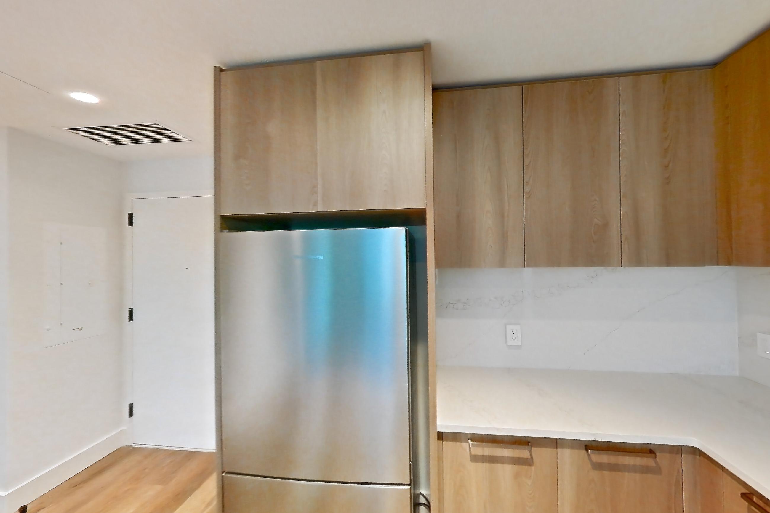 Kitchen with cooktop, electric cooktop, electric range, light stone countertops, light wood-finish flooring, microwave, oven/range, refrigerator, and stainless steel appliances, Unit 0626 at Hearthstone