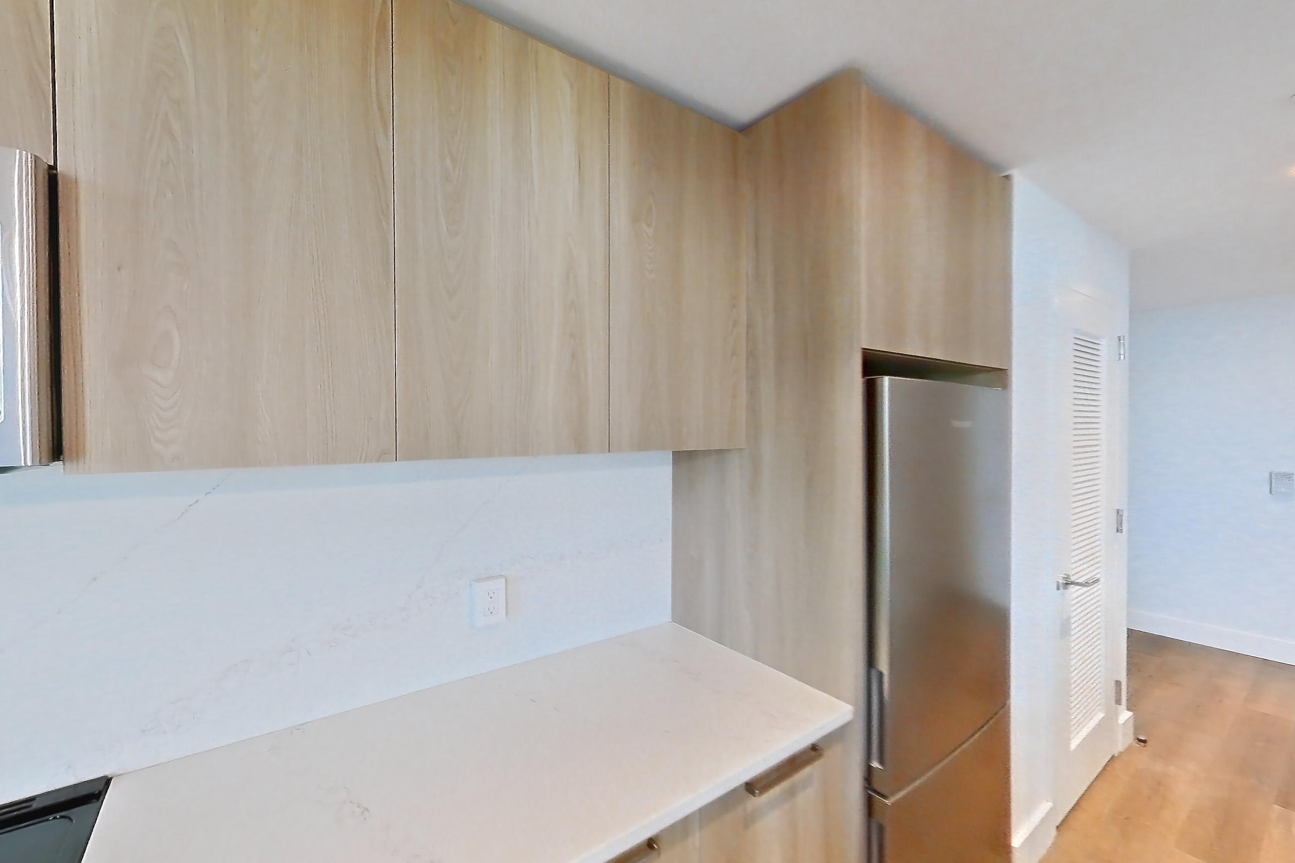 Kitchen with electric range, light countertops, light stone countertops, light wood-finish flooring, microwave, oven/range, refrigerator, and stainless steel appliances, Unit 0625 at Hearthstone