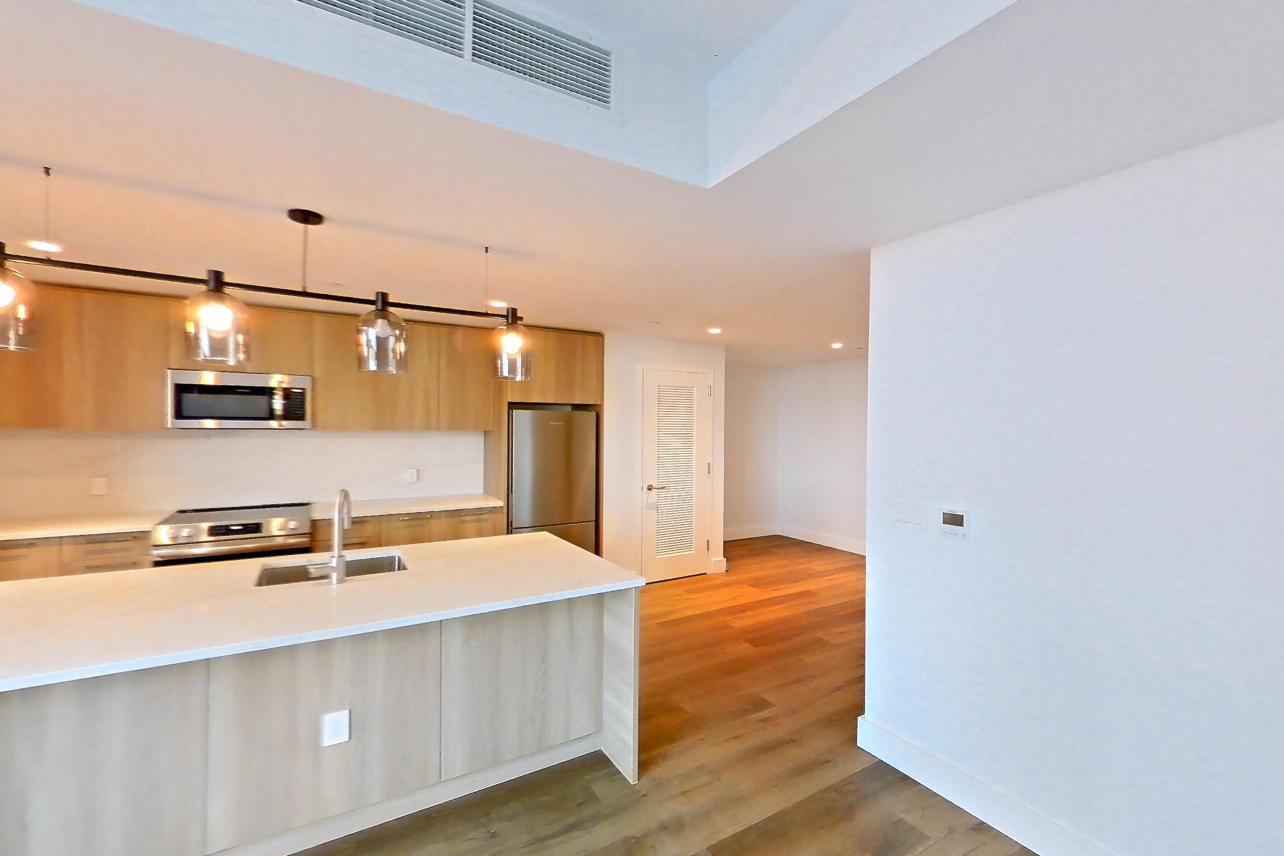 Living room with dark wood-finish flooring, electric range, kitchen island, light stone countertops, light wood-finish flooring, microwave, oven/range, refrigerator, and stainless steel appliances, Unit 0625 at Hearthstone