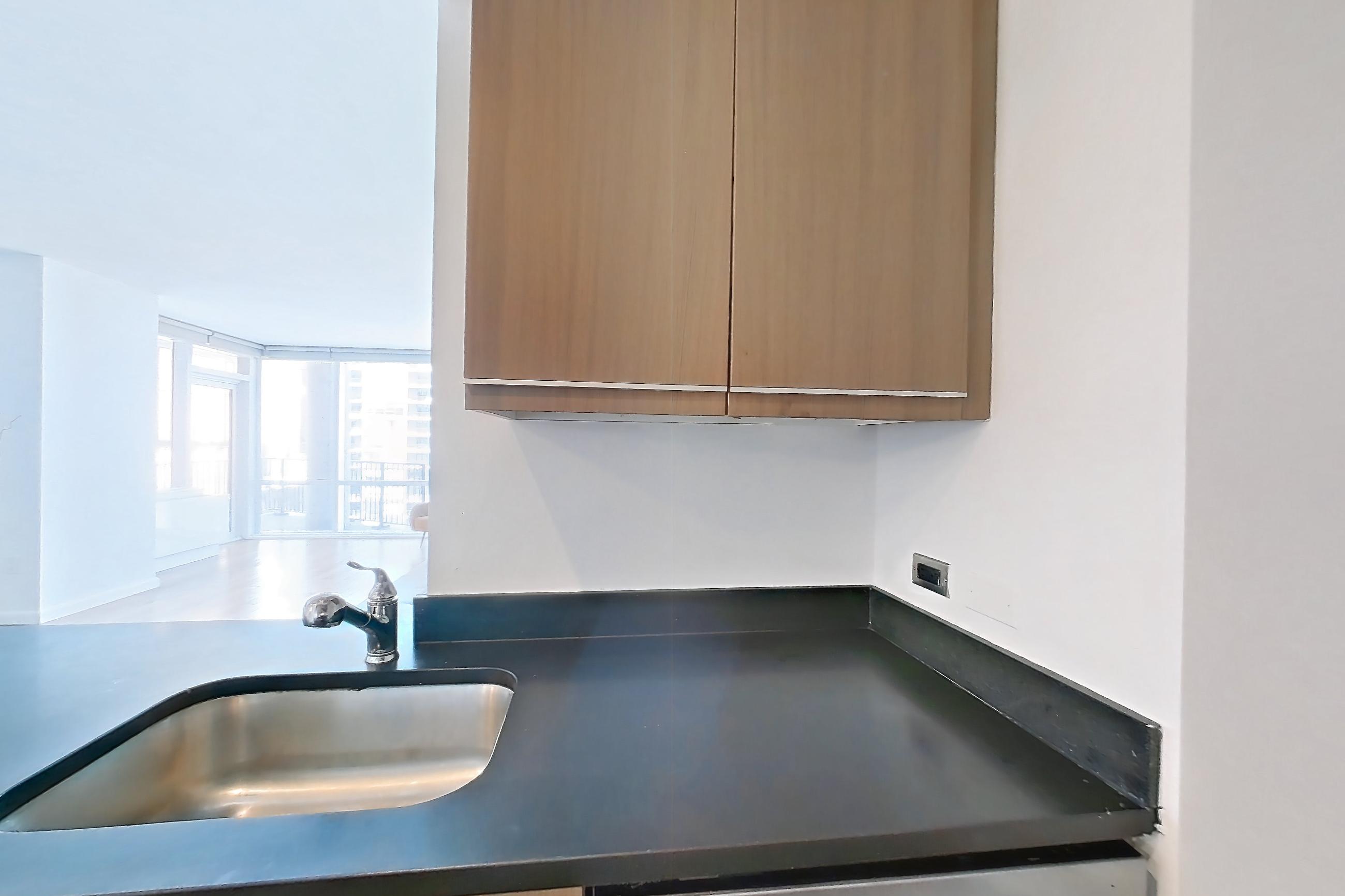 Kitchen with black appliances, dark countertops, dark tile flooring, dishwasher, gas range, light tile flooring, microwave, oven/range, refrigerator, and stainless steel appliances, Apartment 16A at 66 Rockwell