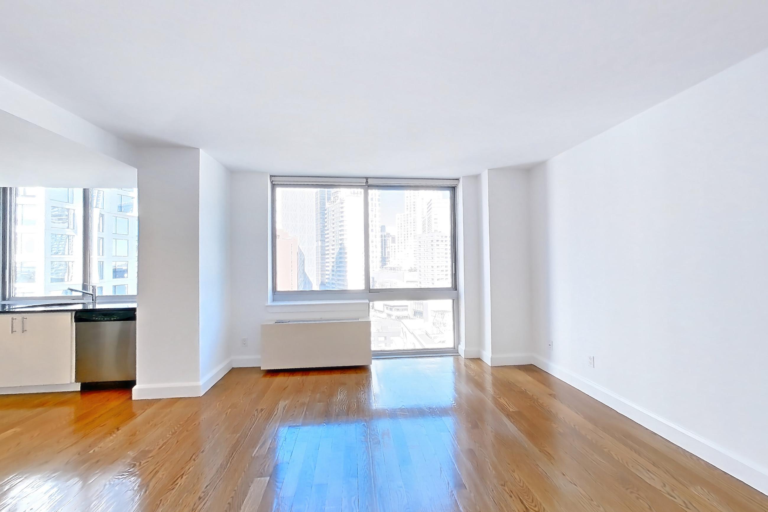 Living space with dark countertops, dishwasher, gas range, light countertops, light wood-finish flooring, microwave, oven/range, refrigerator, and stainless steel appliances, Apartment 18A at The Addison