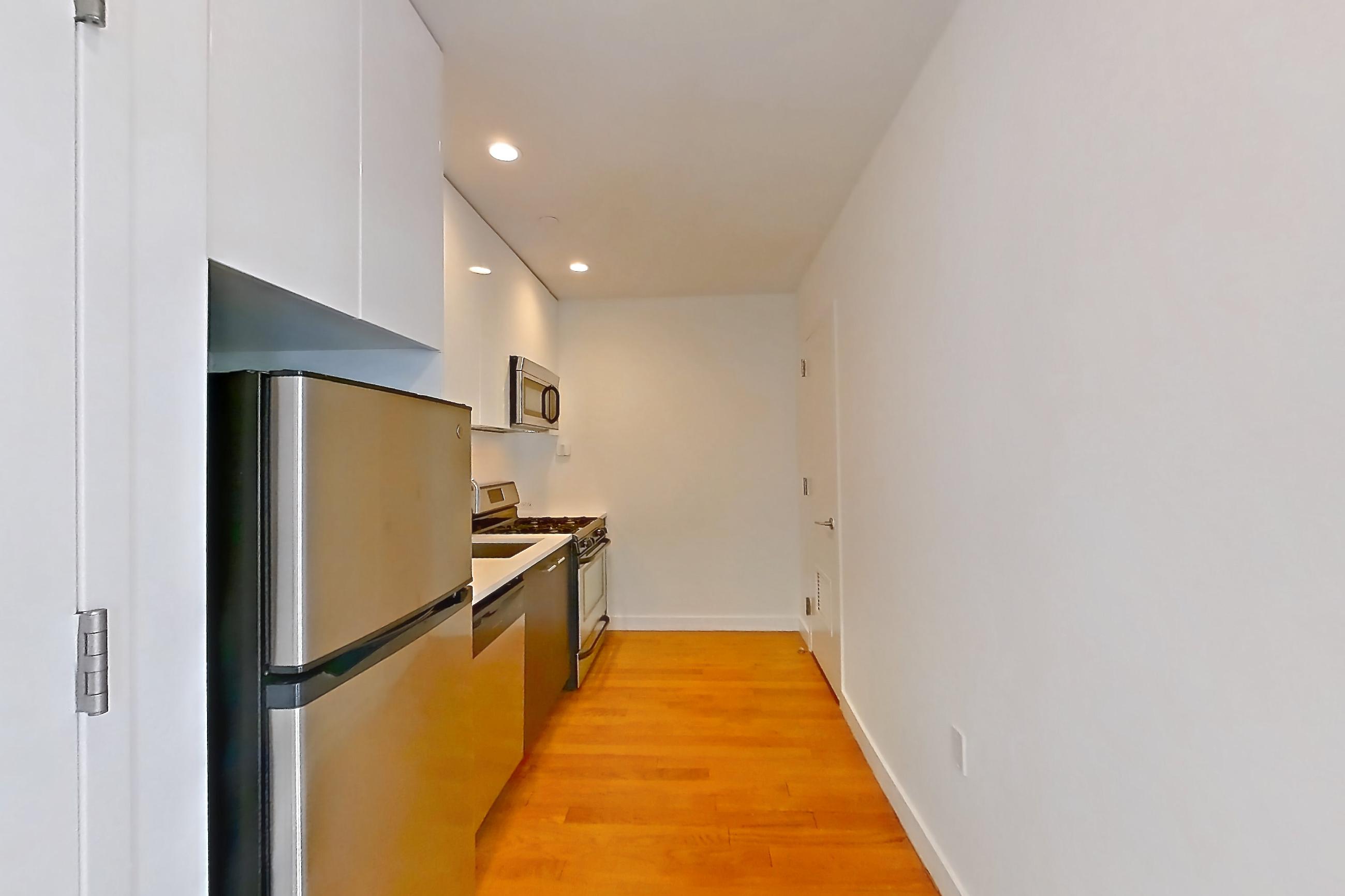 Kitchen 1 with air conditioning, dishwasher, gas range, light wood-finish flooring, oven/range, refrigerator, and stainless steel appliances, Apartment 707 at The Bergen