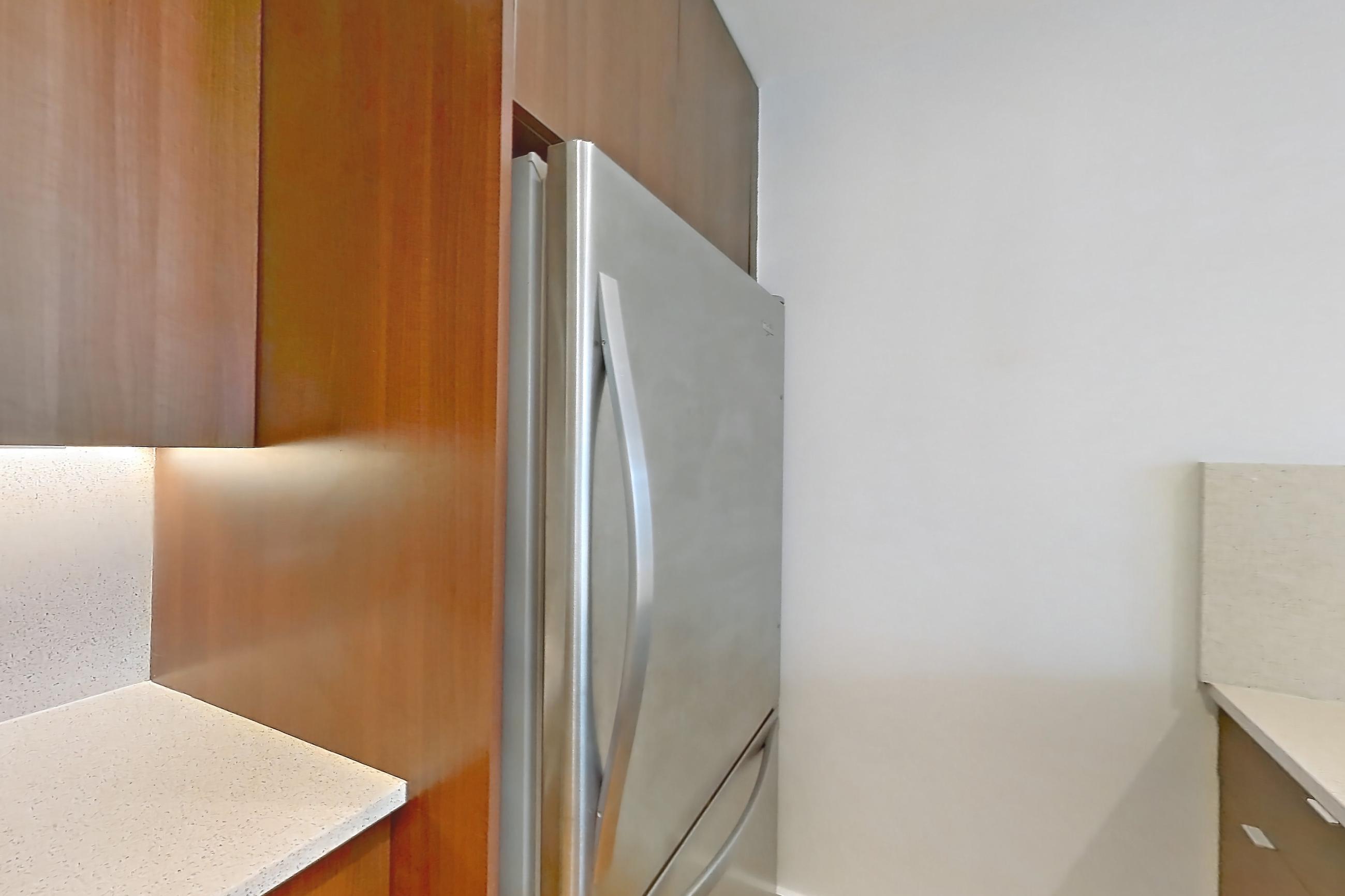 Kitchen with cooktop, dishwasher, gas cooktop, kitchen island, light stone countertops, light wood-finish flooring, oven/range, refrigerator, and stainless steel appliances, Apartment 3L at The Kestrel