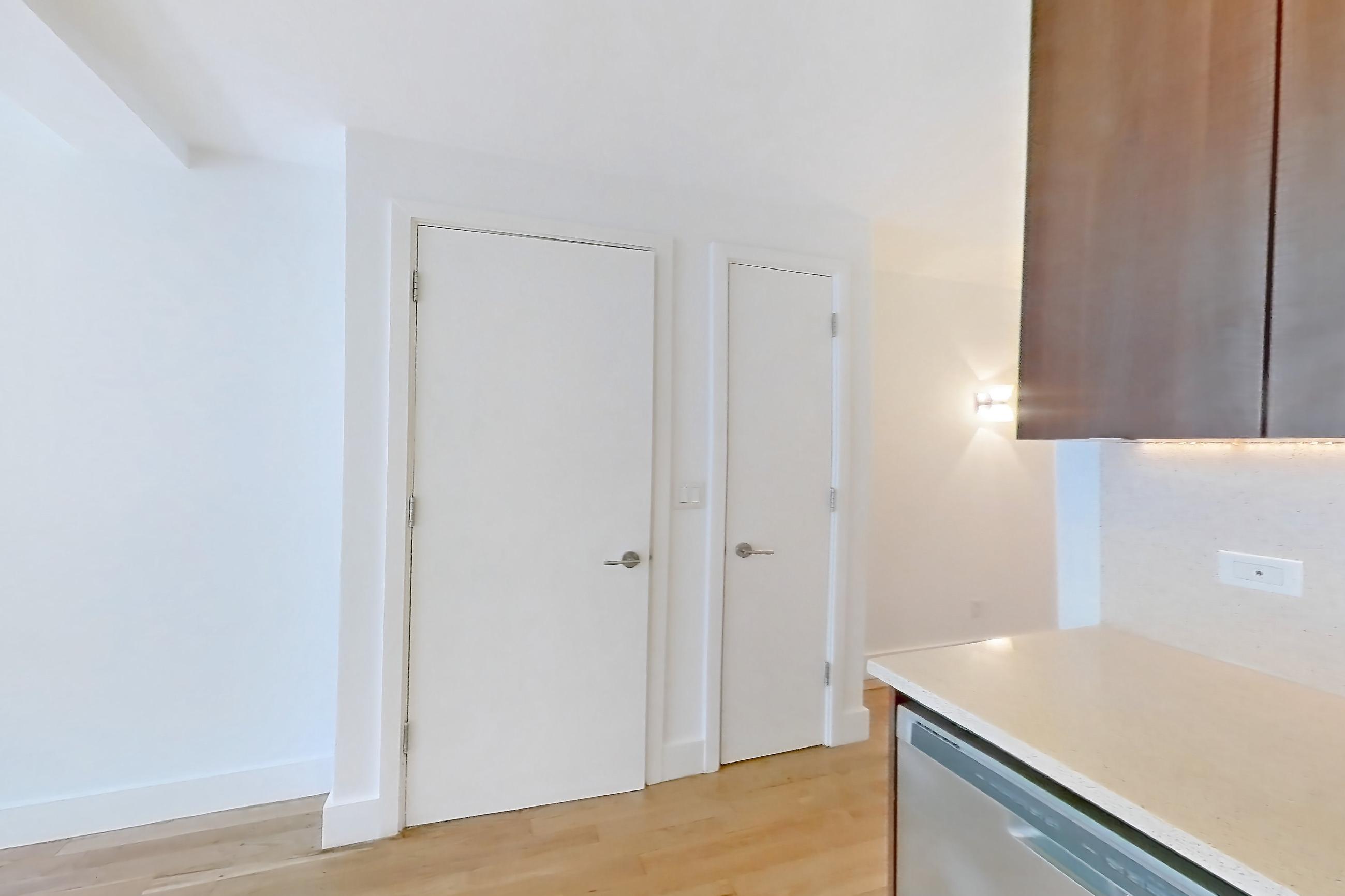 Kitchen with cooktop, dishwasher, gas cooktop, light countertops, light stone countertops, light wood-finish flooring, oven/range, refrigerator, stainless steel appliances, and white appliances, Apartment 6H at The Kestrel