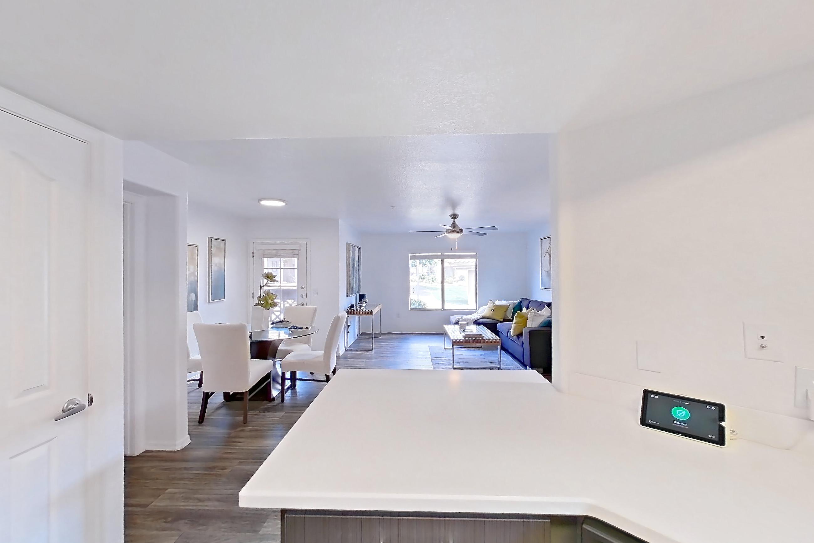 Kitchen with black appliances, dark wood-finish flooring, dishwasher, light countertops, and oven/range, Apartment 1012 at The Palms On Scottsdale