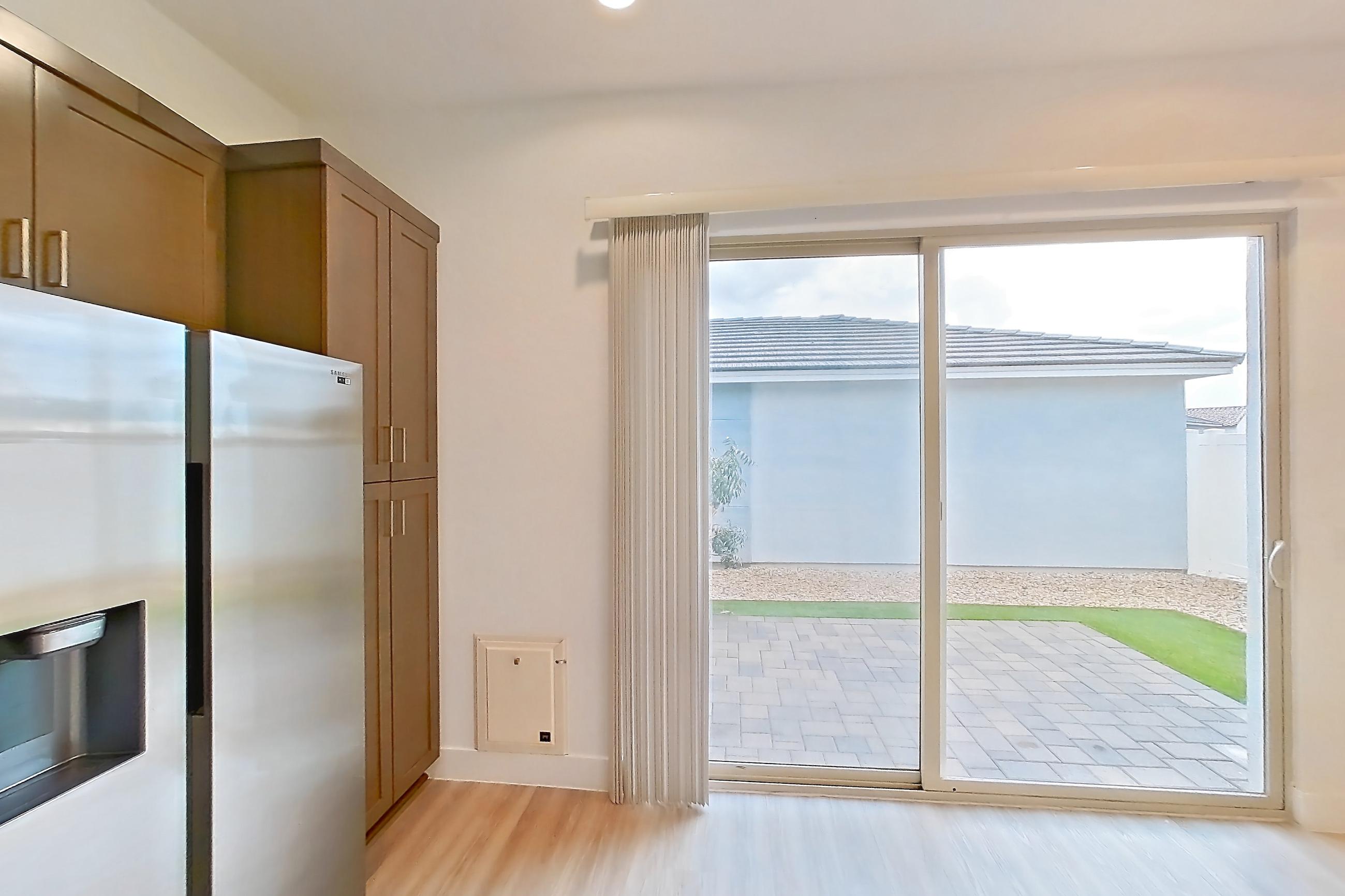 Kitchen with dishwasher, electric range, light countertops, light wood-finish flooring, microwave, oven/range, refrigerator, stainless steel appliances, and water & ice dispenser, Apartment 1A at Tavalo At Cadence