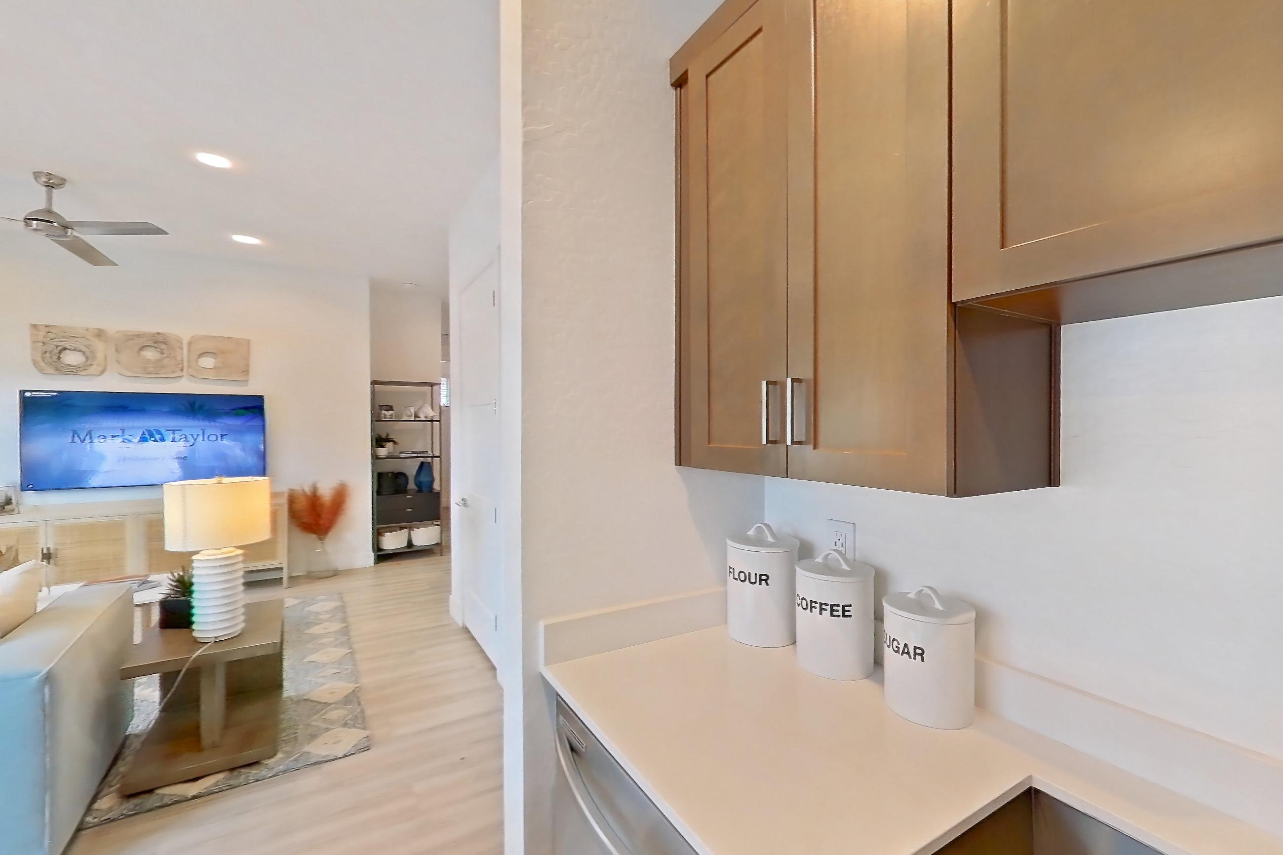 Kitchen with dishwasher, electric range, light countertops, light wood-finish flooring, microwave, oven/range, refrigerator, stainless steel appliances, water & ice dispenser, and white appliances, Apartment 2A at Tavalo At Cadence
