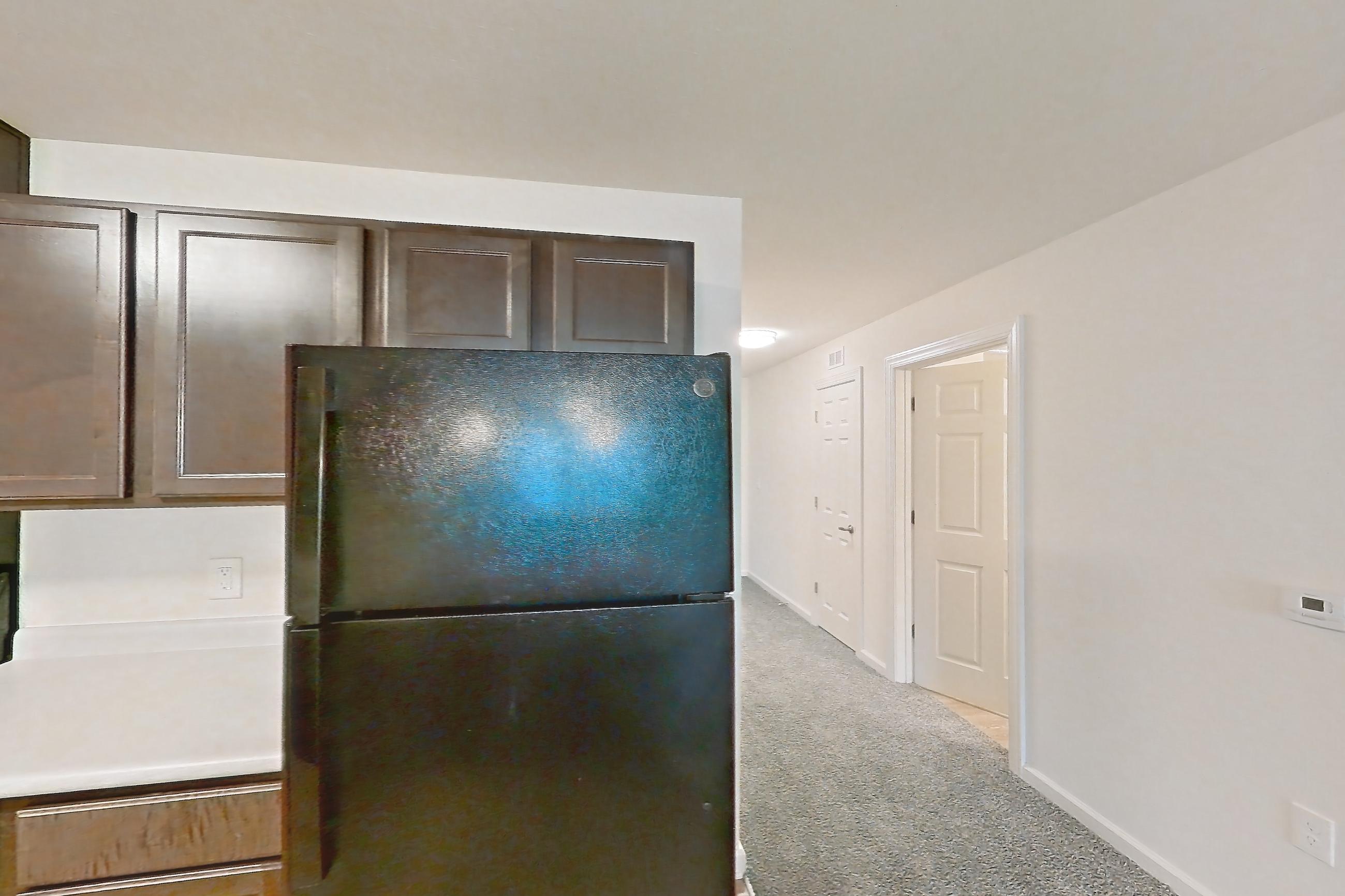 Kitchen with black appliances, dishwasher, electric range, light countertops, light wood-finish flooring, oven/range, and refrigerator, Apartment 4L at Springbrook