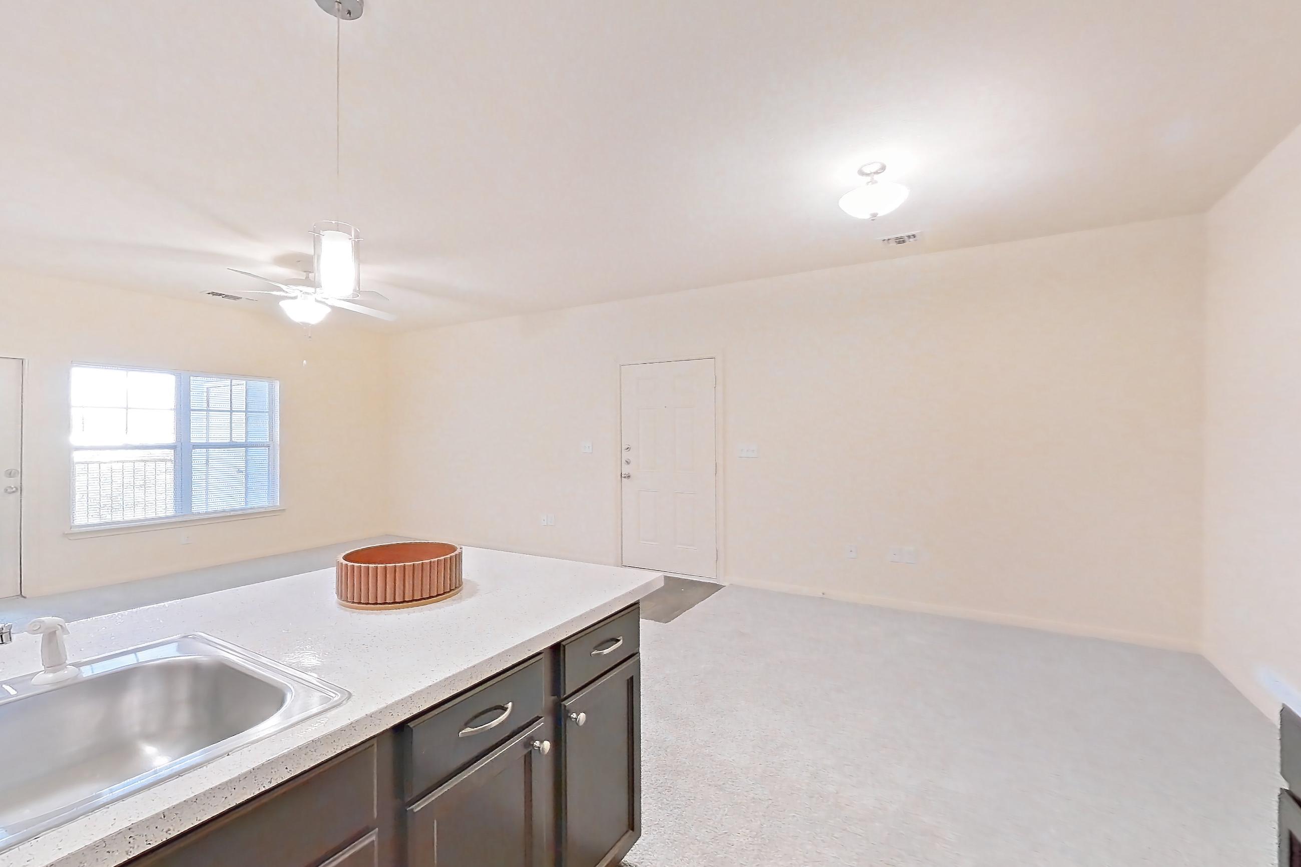 Kitchen with black appliances, dark carpet, dark wood-finish flooring, dishwasher, electric range, light countertops, light stone countertops, microwave, oven/range, and refrigerator, Apartment 1232 at William Cannon