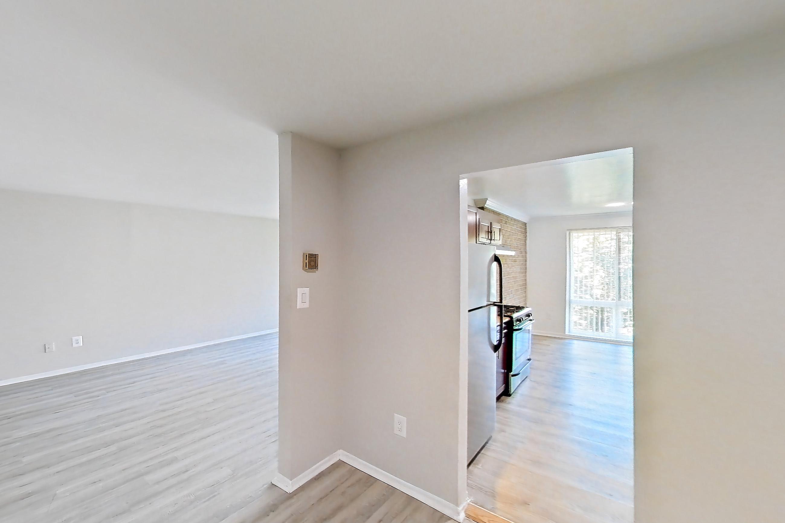 Dining room with gas range, light wood-finish flooring, oven/range, refrigerator, stainless steel appliances, and white appliances, Apartment 9320ER33 at Franklin Park at Greenbelt Station
