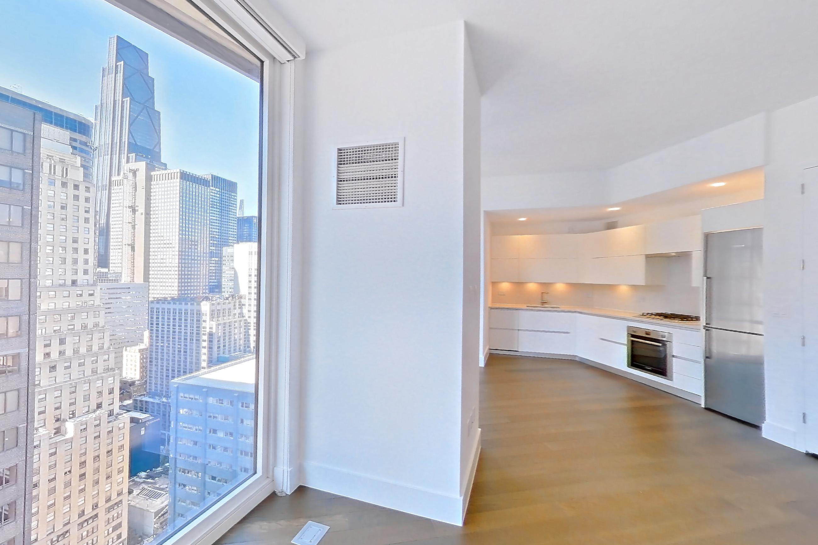 Living space with cooktop, dark wood-finish flooring, gas cooktop, light countertops, oven/range, refrigerator, stainless steel appliances, white appliances, and wood-finish flooring, Apartment 28M at Summit NYC