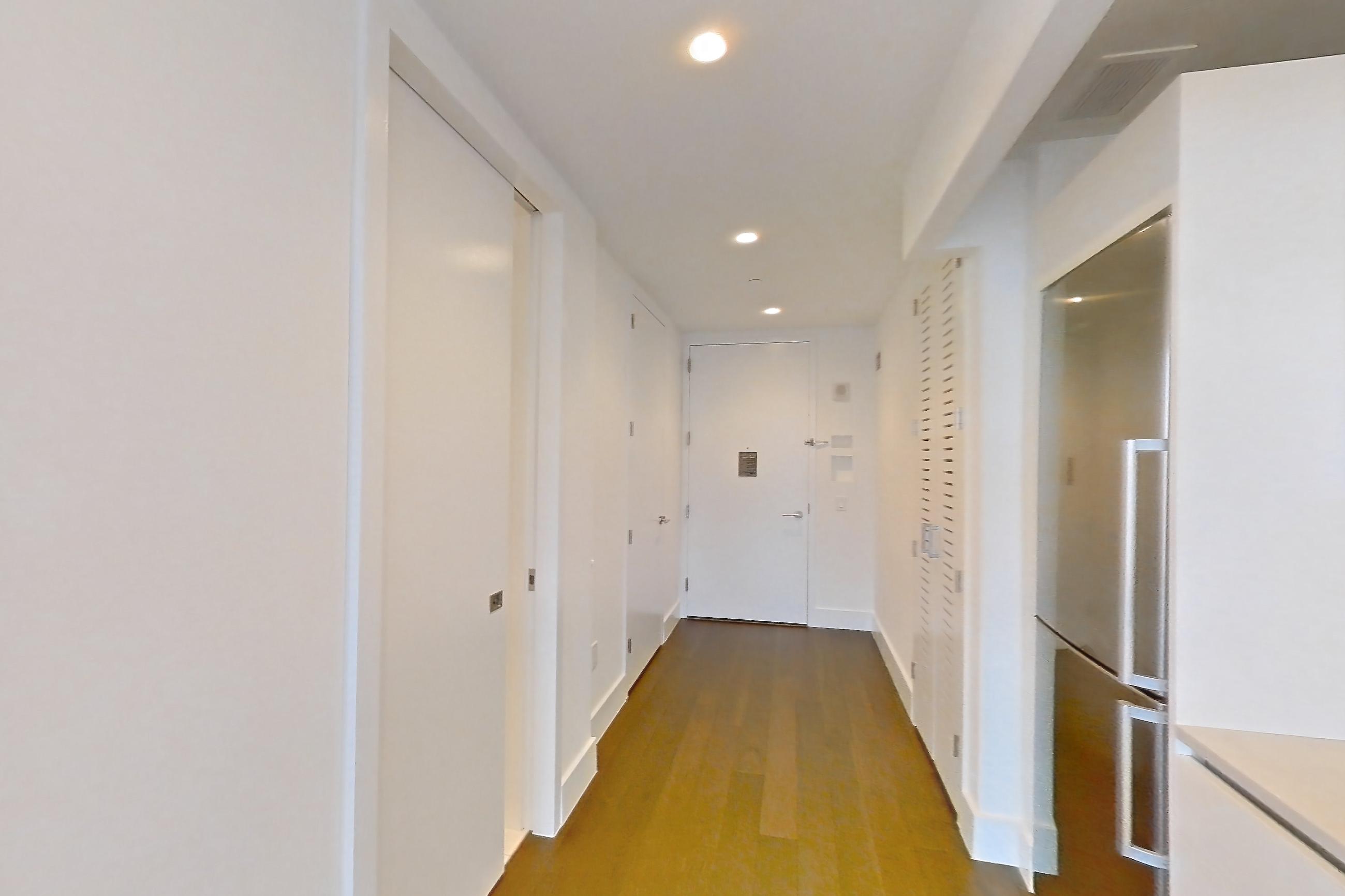 Kitchen with cooktop, dark wood-finish flooring, dishwasher, gas cooktop, light countertops, light stone countertops, microwave, oven/range, refrigerator, skyline view, stainless steel appliances, and wood-finish flooring, Apartment 38C at Summit NYC
