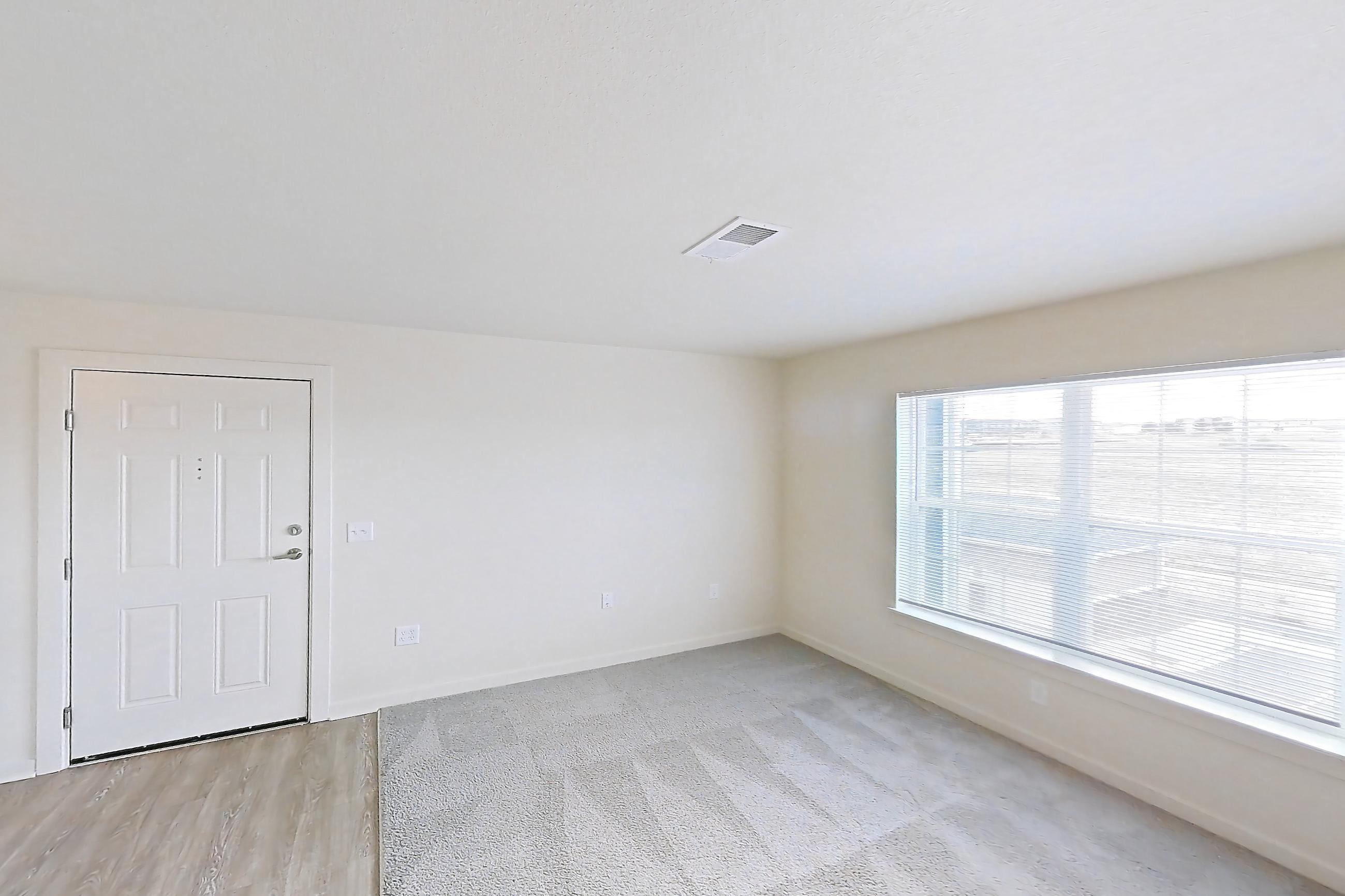 Living space with black appliances, electric range, light carpet, light countertops, oven/range, and refrigerator, Apartment 4Q at The Creek at Cottonwood