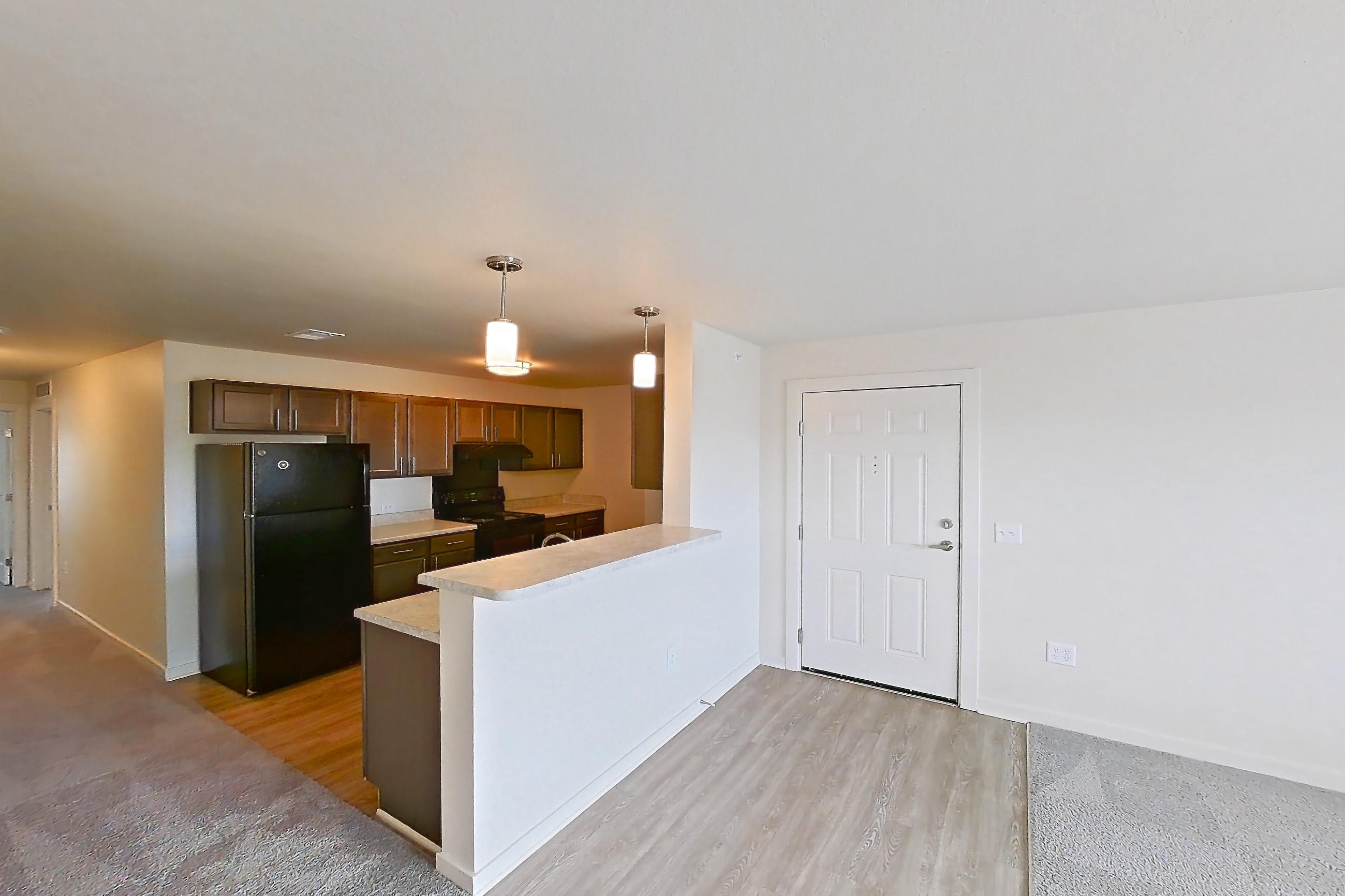 Living space with black appliances, electric range, light carpet, light countertops, oven/range, and refrigerator, Apartment 4Q at The Creek at Cottonwood